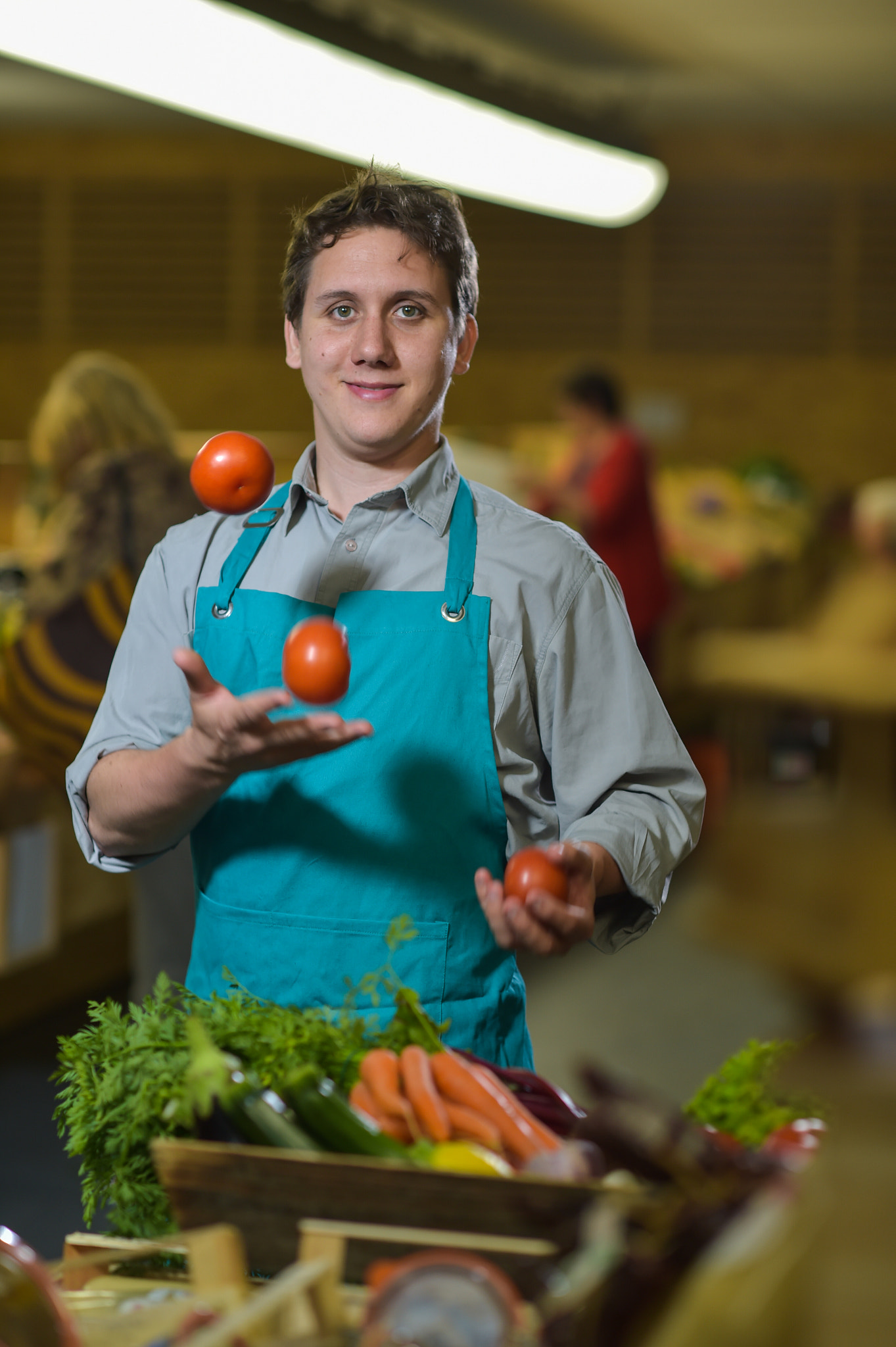 Nikon D4S + Nikon AF-S Nikkor 85mm F1.4G sample photo. Grocery clerk juggling with tomatoes in supermarket store photography