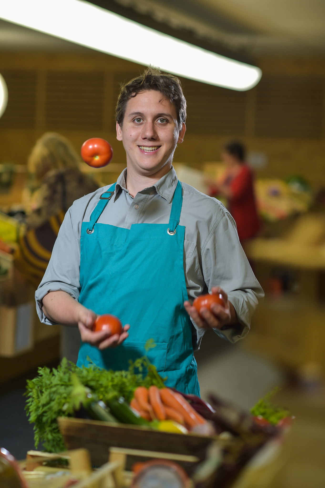 Nikon D4S + Nikon AF-S Nikkor 85mm F1.4G sample photo. Grocery clerk juggling with tomatoes in supermarket store photography