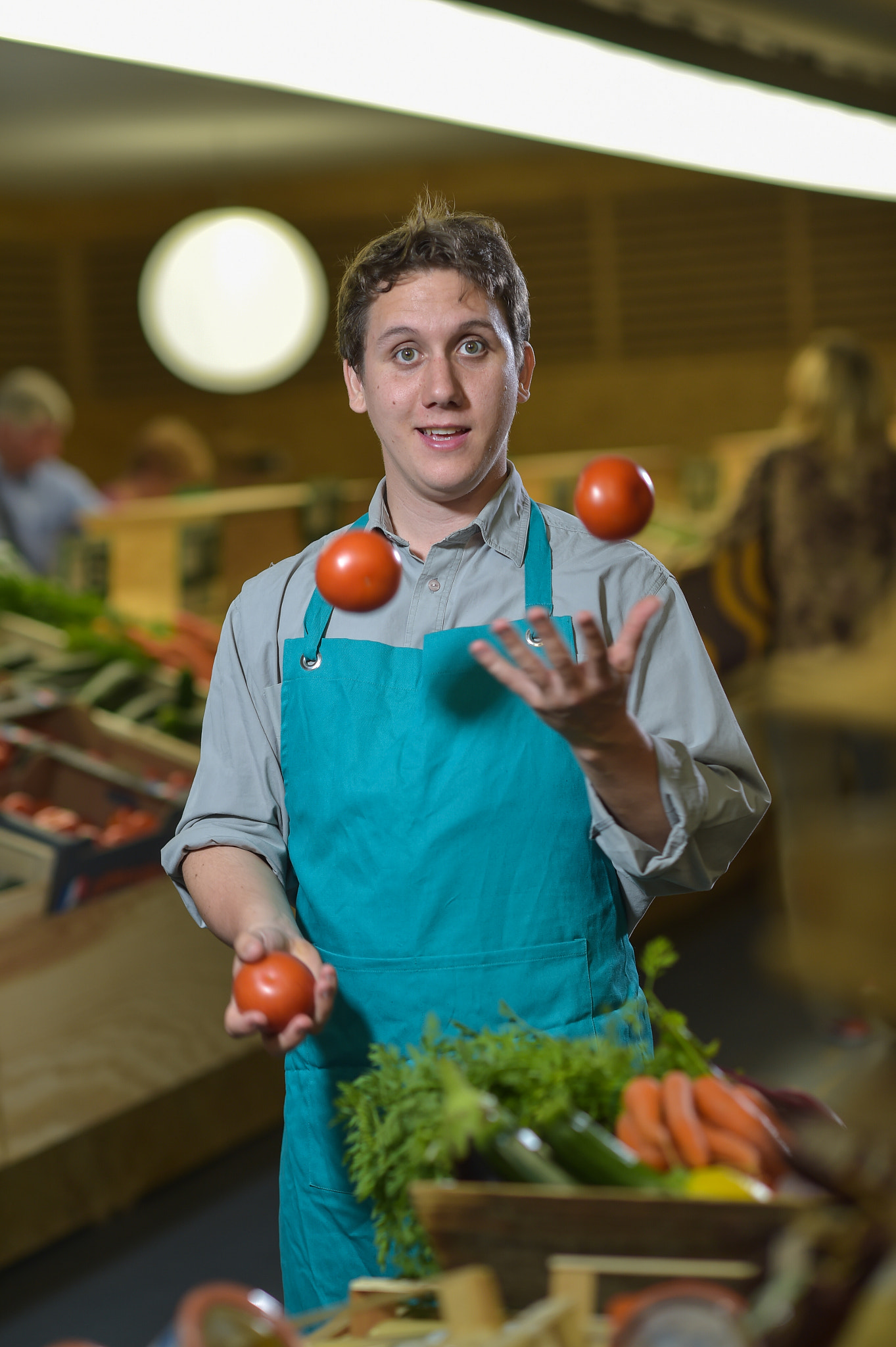 Nikon D4S + Nikon AF-S Nikkor 85mm F1.4G sample photo. Grocery clerk juggling with tomatoes in supermarket store photography
