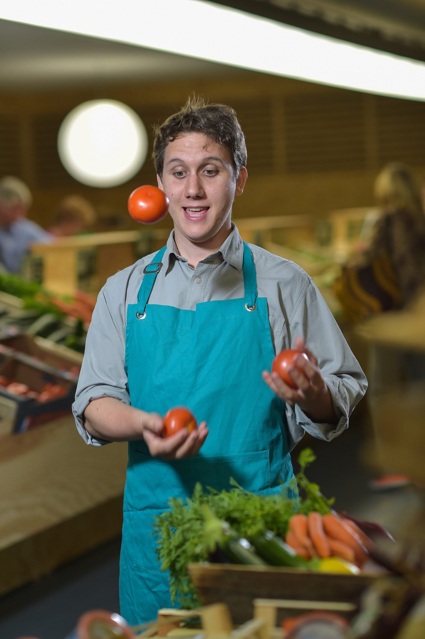 Nikon D4S + Nikon AF-S Nikkor 85mm F1.4G sample photo. Grocery clerk juggling with tomatoes in supermarket store photography