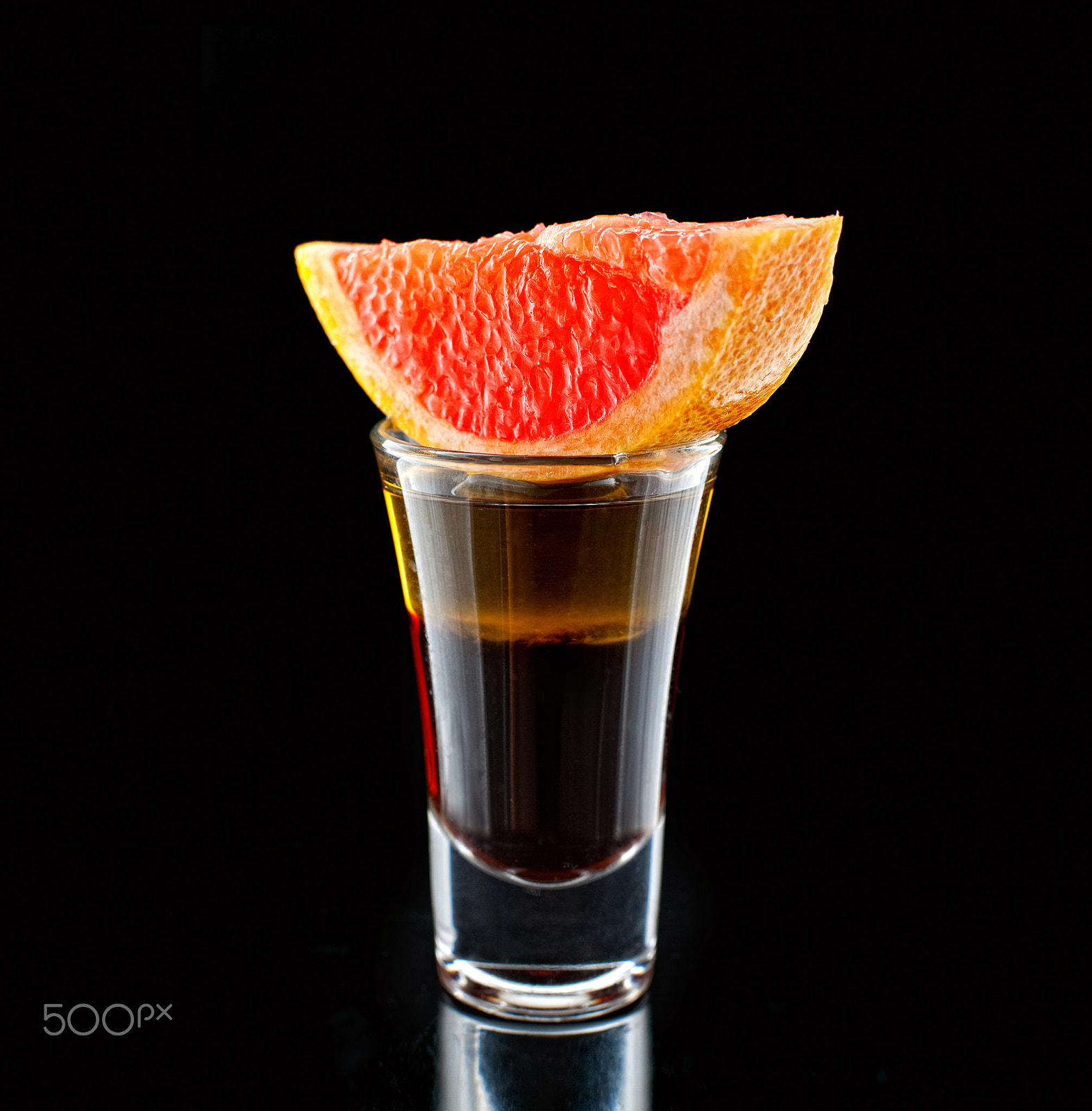Canon EF 50mm F1.4 USM sample photo. Glass with grapefruit liqueur close-up shot on black background photography