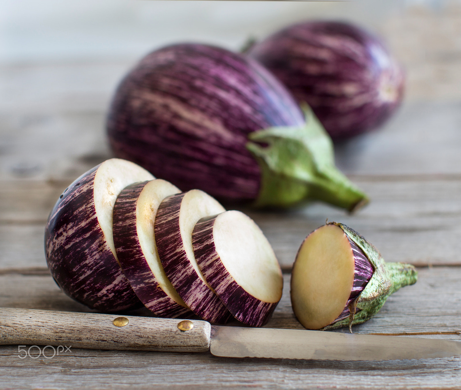 Canon EOS 650D (EOS Rebel T4i / EOS Kiss X6i) + Canon EF 50mm F1.2L USM sample photo. Fresh raw striped eggplants and slices with knife photography