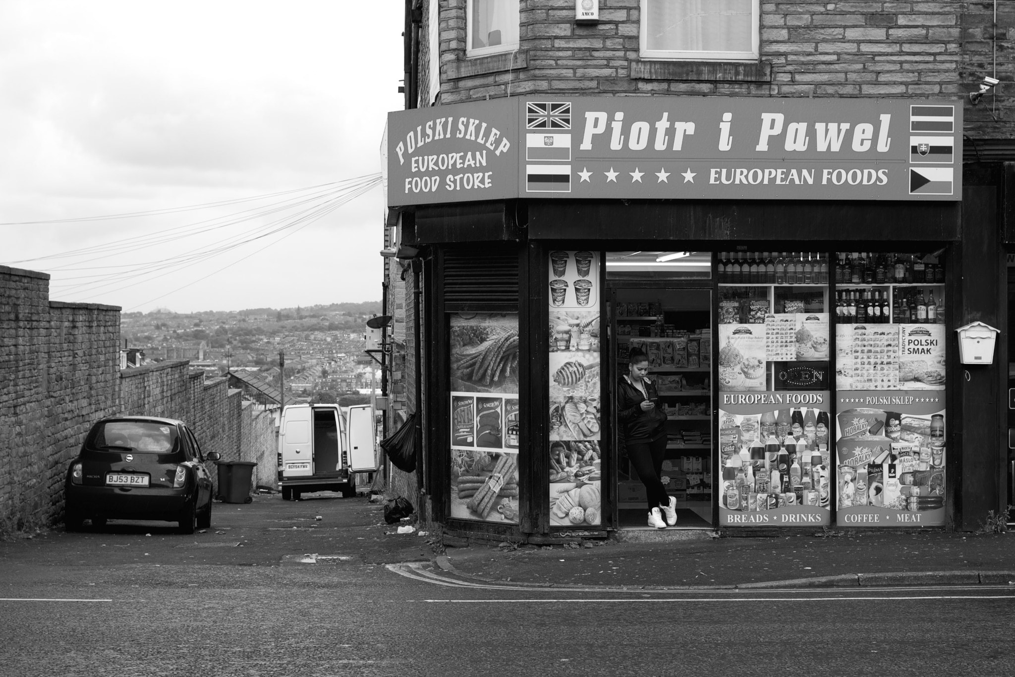 Canon EOS 550D (EOS Rebel T2i / EOS Kiss X4) + Canon EF 40mm F2.8 STM sample photo. Bored shop assistant at a polish corner shop, bradford, england. photography