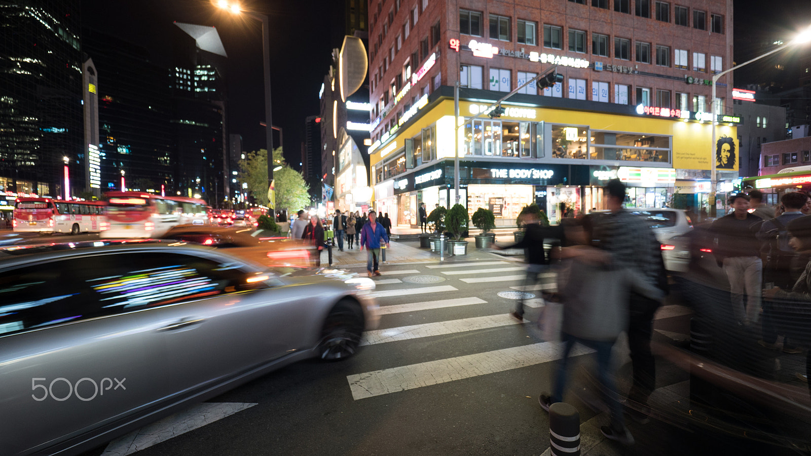 Panasonic Lumix DMC-GH4 + Olympus M.Zuiko Digital ED 7-14mm F2.8 PRO sample photo. Pedestrians on zebra crossing in night seoul, south korea photography