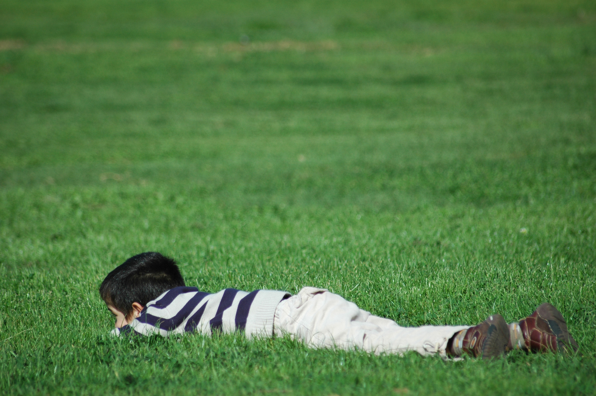Sigma 70-300mm F4-5.6 APO Macro Super II sample photo. Boy resting on grassy hill photography