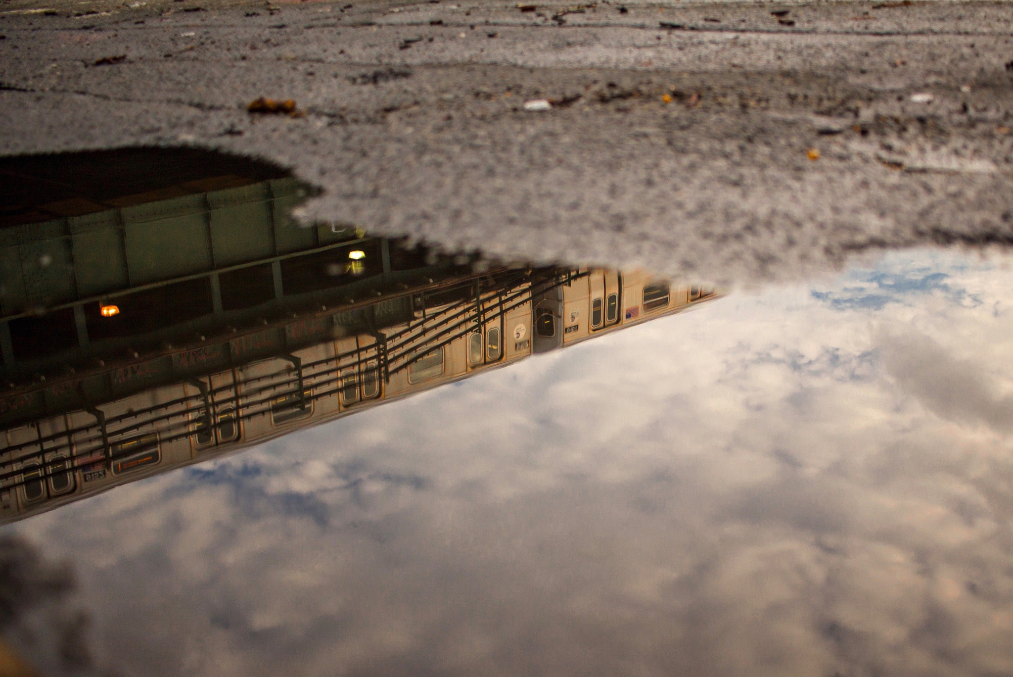 Canon EF-S 24mm F2.8 STM sample photo. N train through puddle in astoria, nyc photography