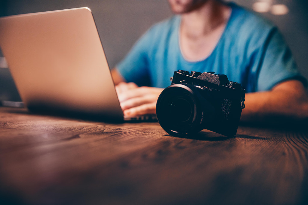 Man doing postproduction of his photos on laptop at night by Carina König on 500px.com