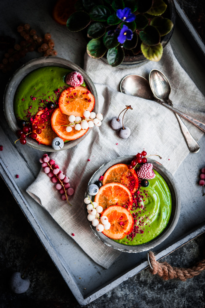 Green smoothie bowl with fruits and berries on rustic background by Alena Haurylik on 500px.com
