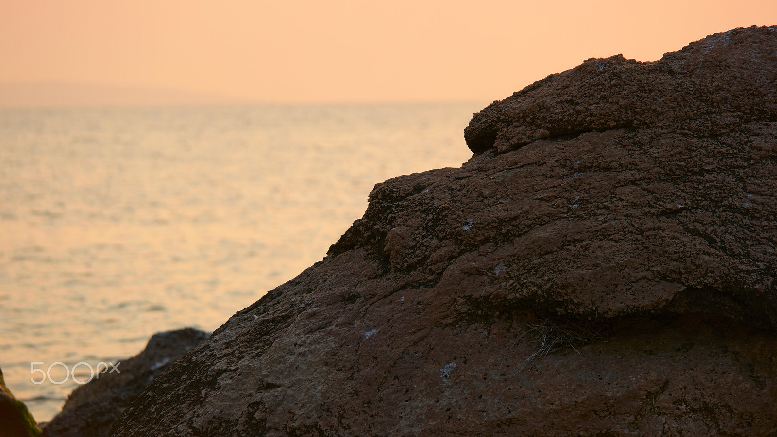 Samsung NX500 + NX 50-200mm F4-5.6 sample photo. Sunset over the ocean, rock in front of sea surface and sky full of warm sunlight photography