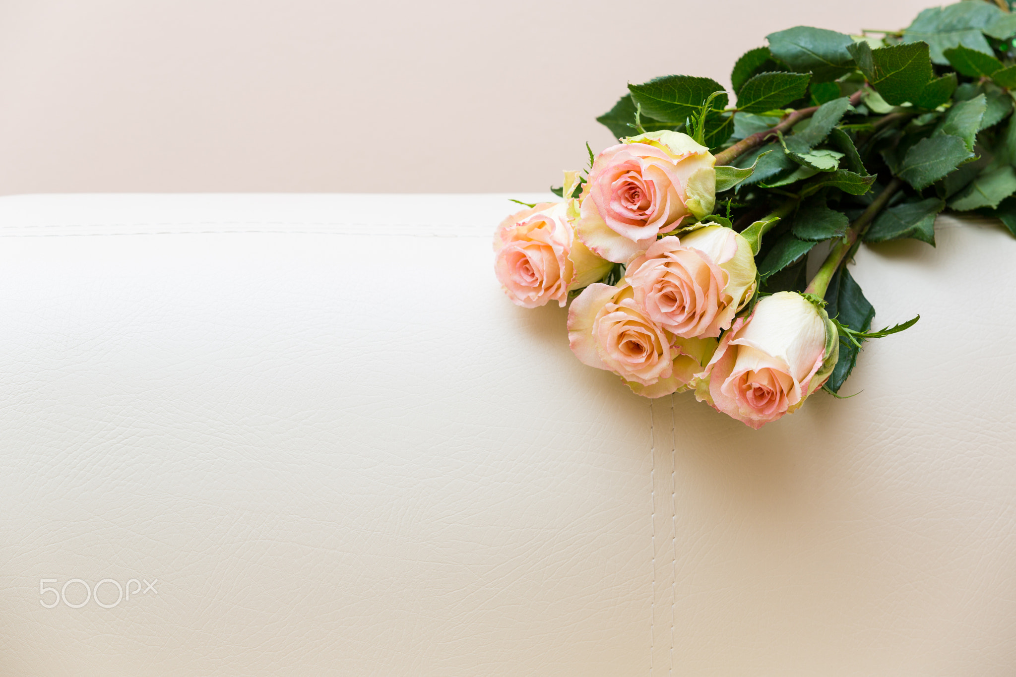 Bouquet of tea roses on a white sofa