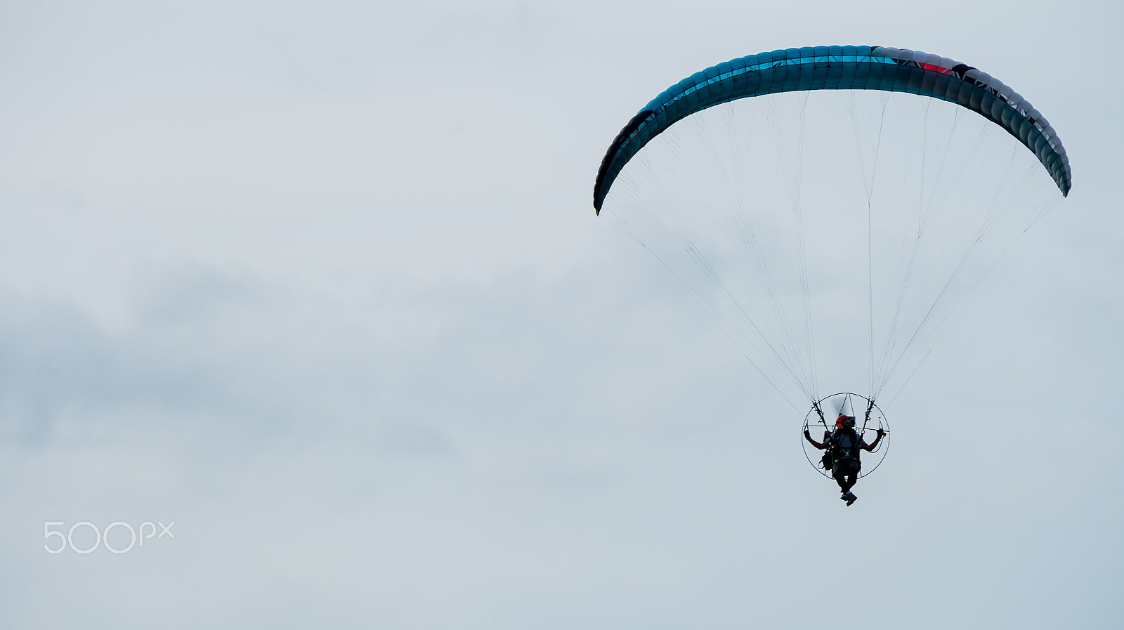 Fujifilm X-A2 + Fujifilm XC 50-230mm F4.5-6.7 OIS II sample photo. Paraglider flies on background of sunset sky photography