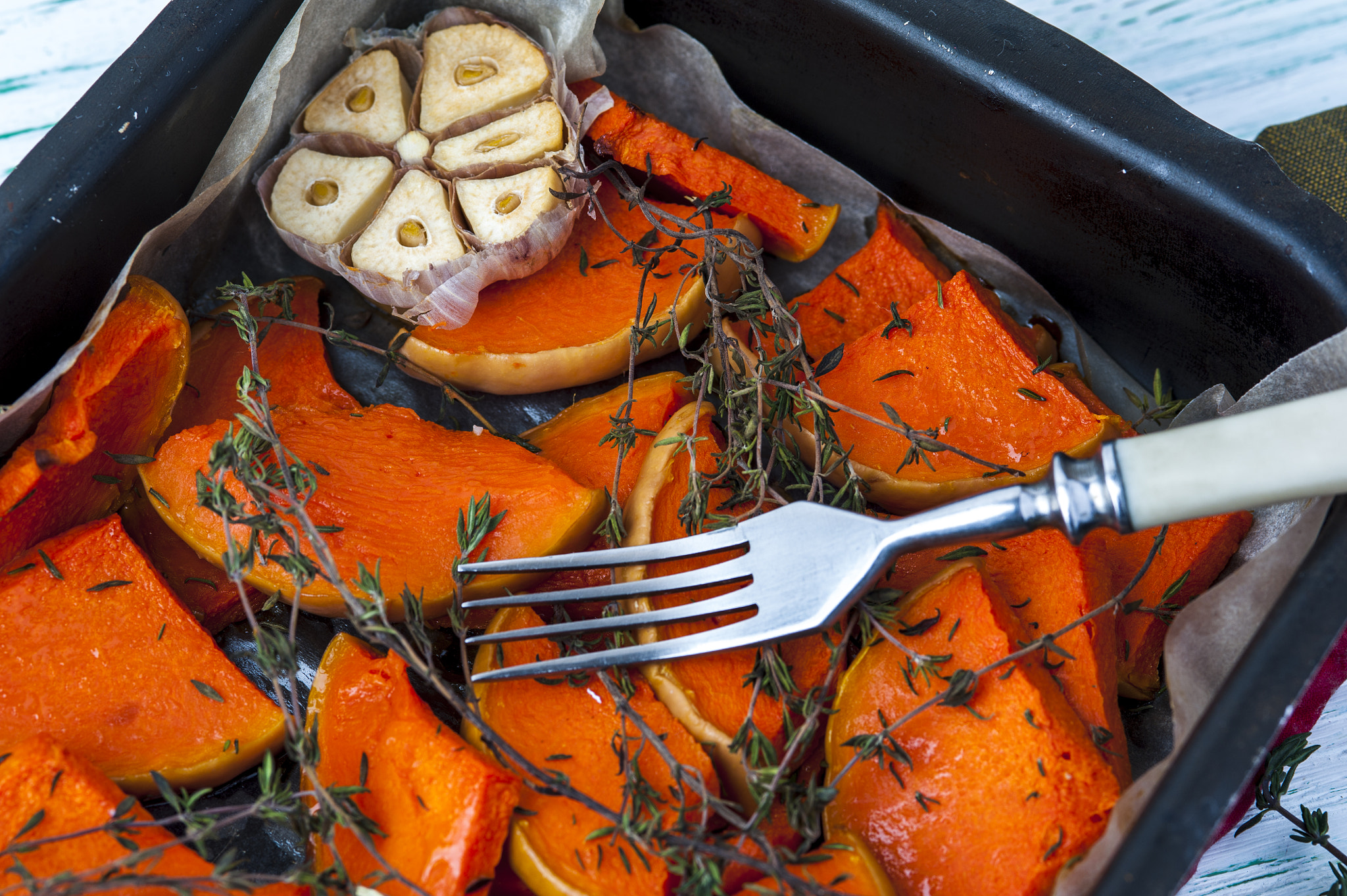 Nikon D700 + AF Micro-Nikkor 105mm f/2.8 sample photo. Baked pumpkin with thyme, olive oil and garlic on baking tray with fork on wooden background.... photography