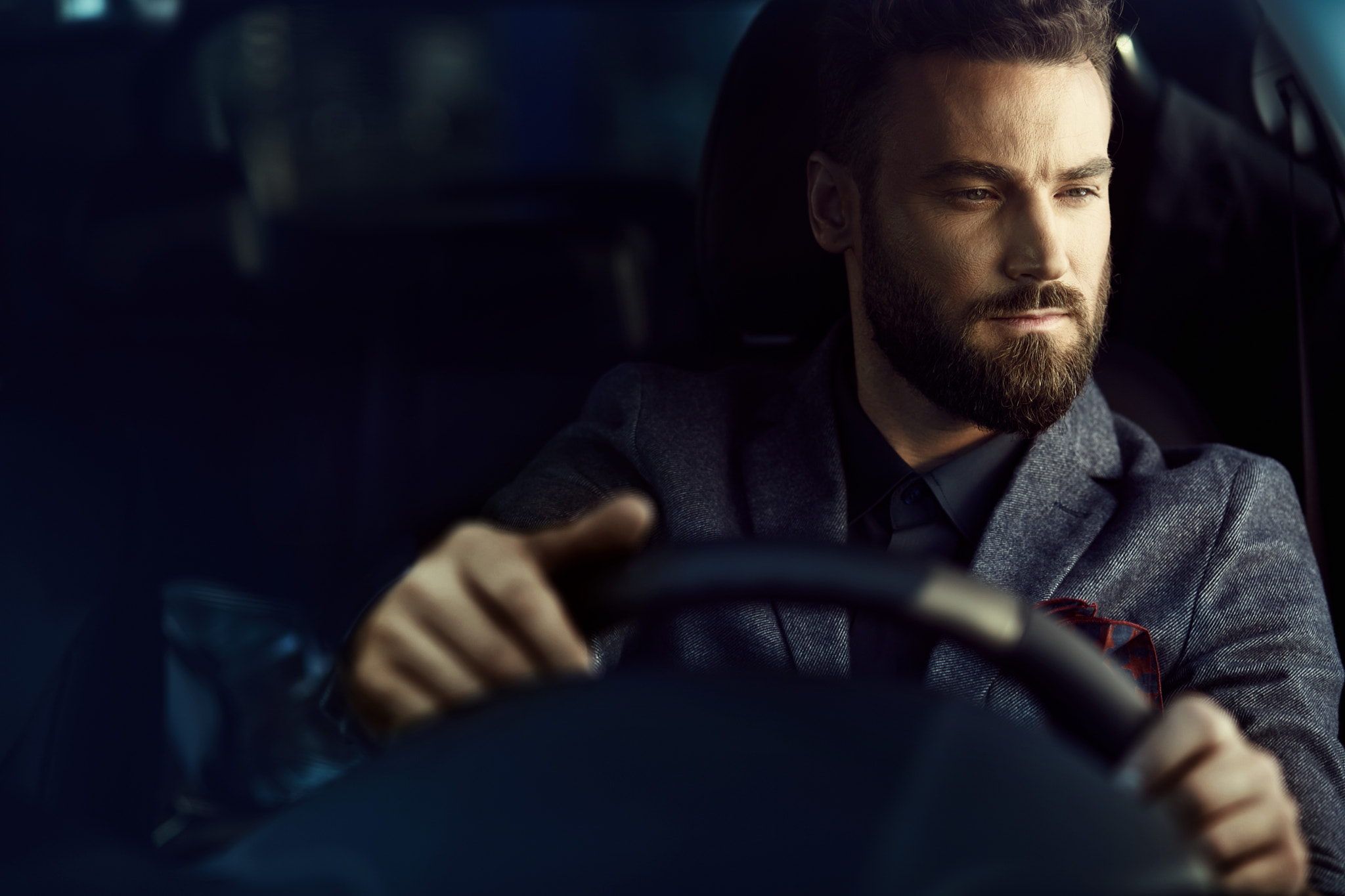A nice man with a beard driving