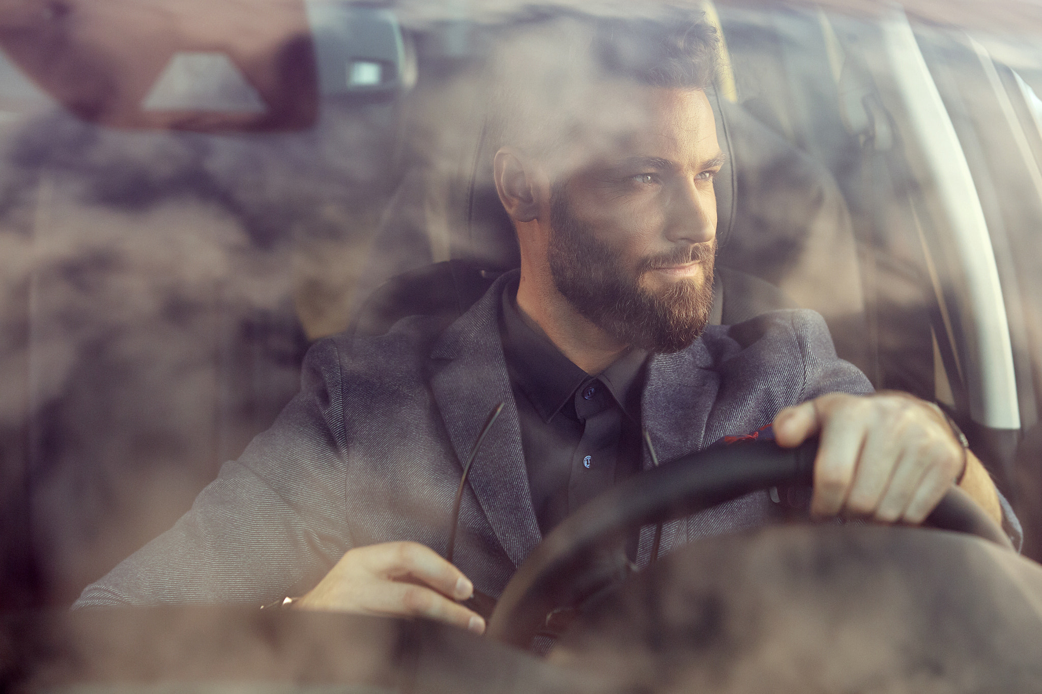 A nice man with a beard driving