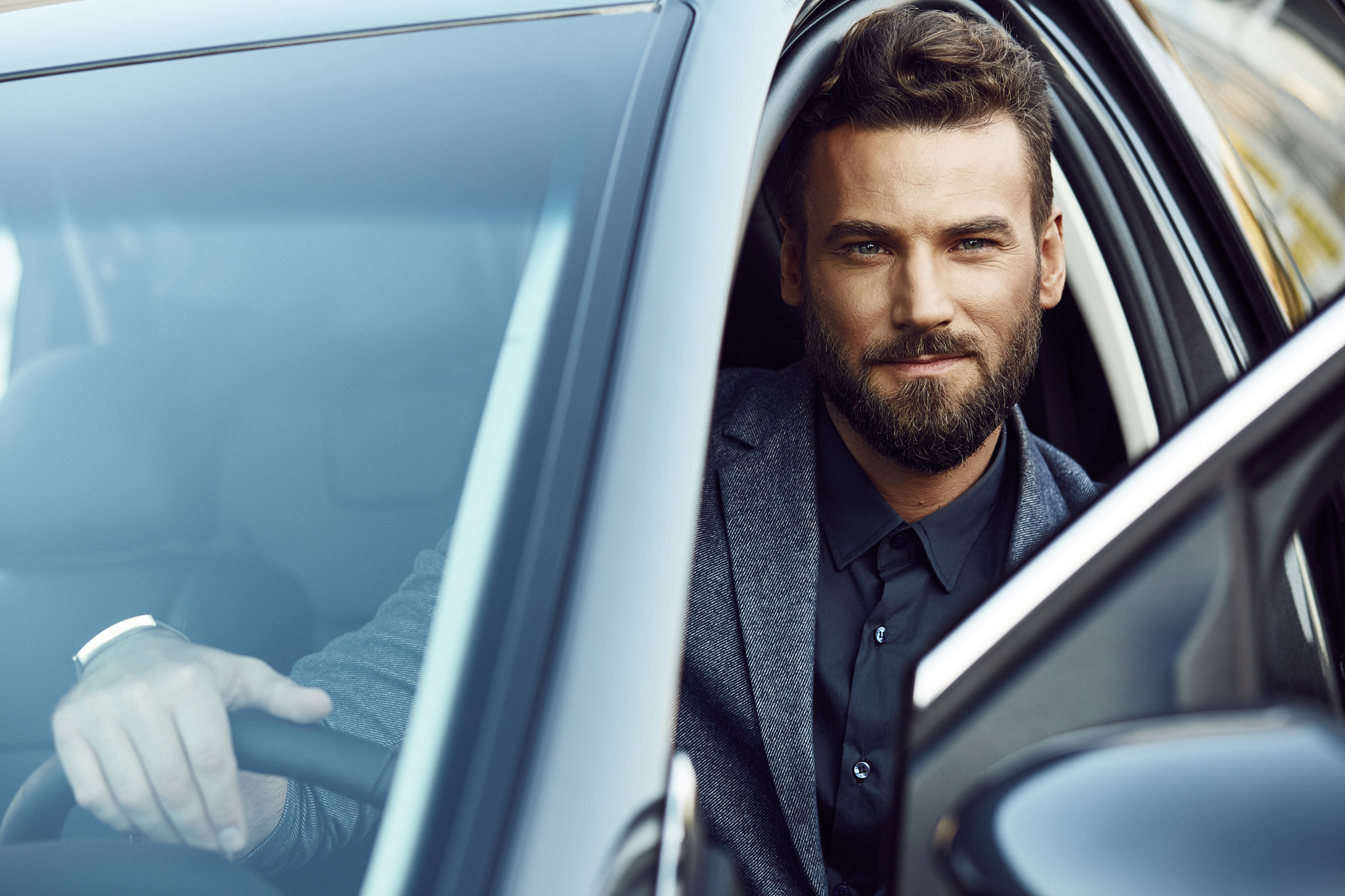 A nice man with a beard driving