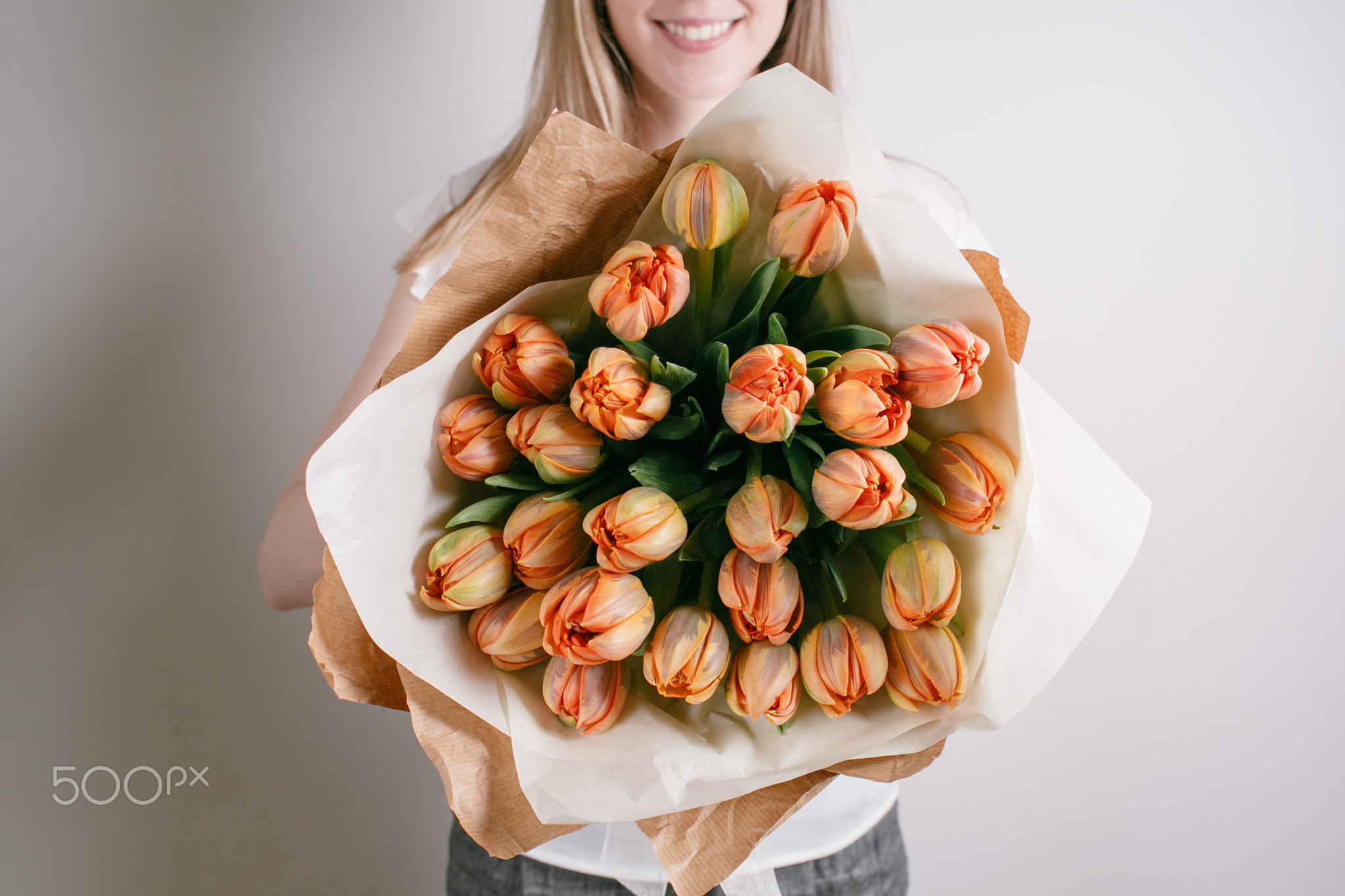 Florist girl with peony flowers or orange tulips Young woman flower bouquet for birthday mother's...