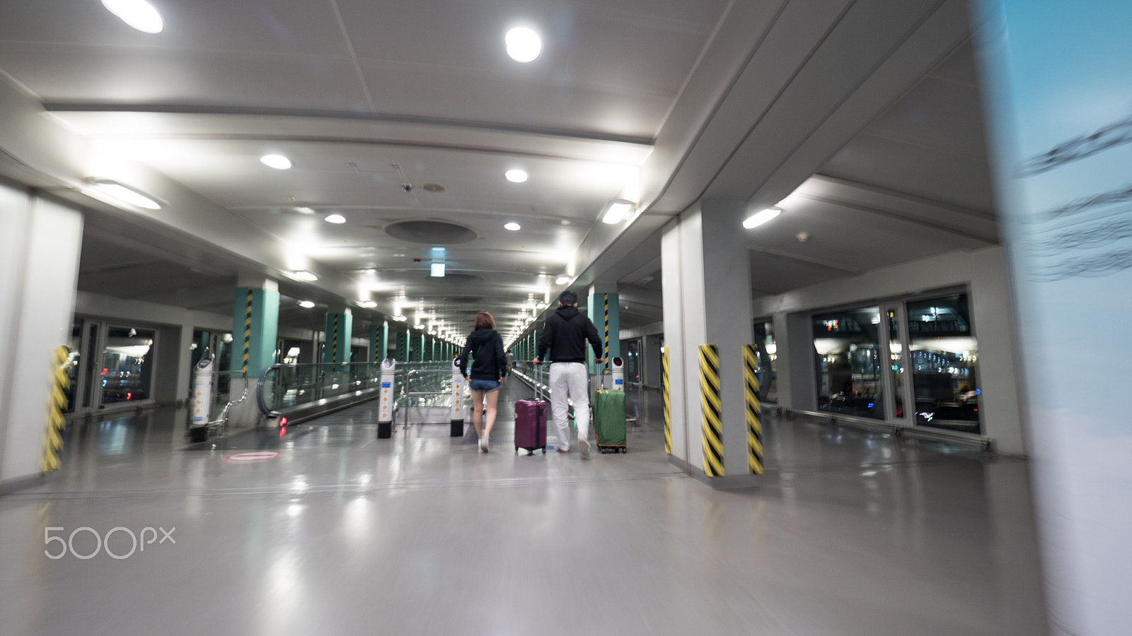 Panasonic Lumix DMC-GH4 + Olympus M.Zuiko Digital ED 7-14mm F2.8 PRO sample photo. Travelers with baggage walking to flat escalator at seoul airport photography