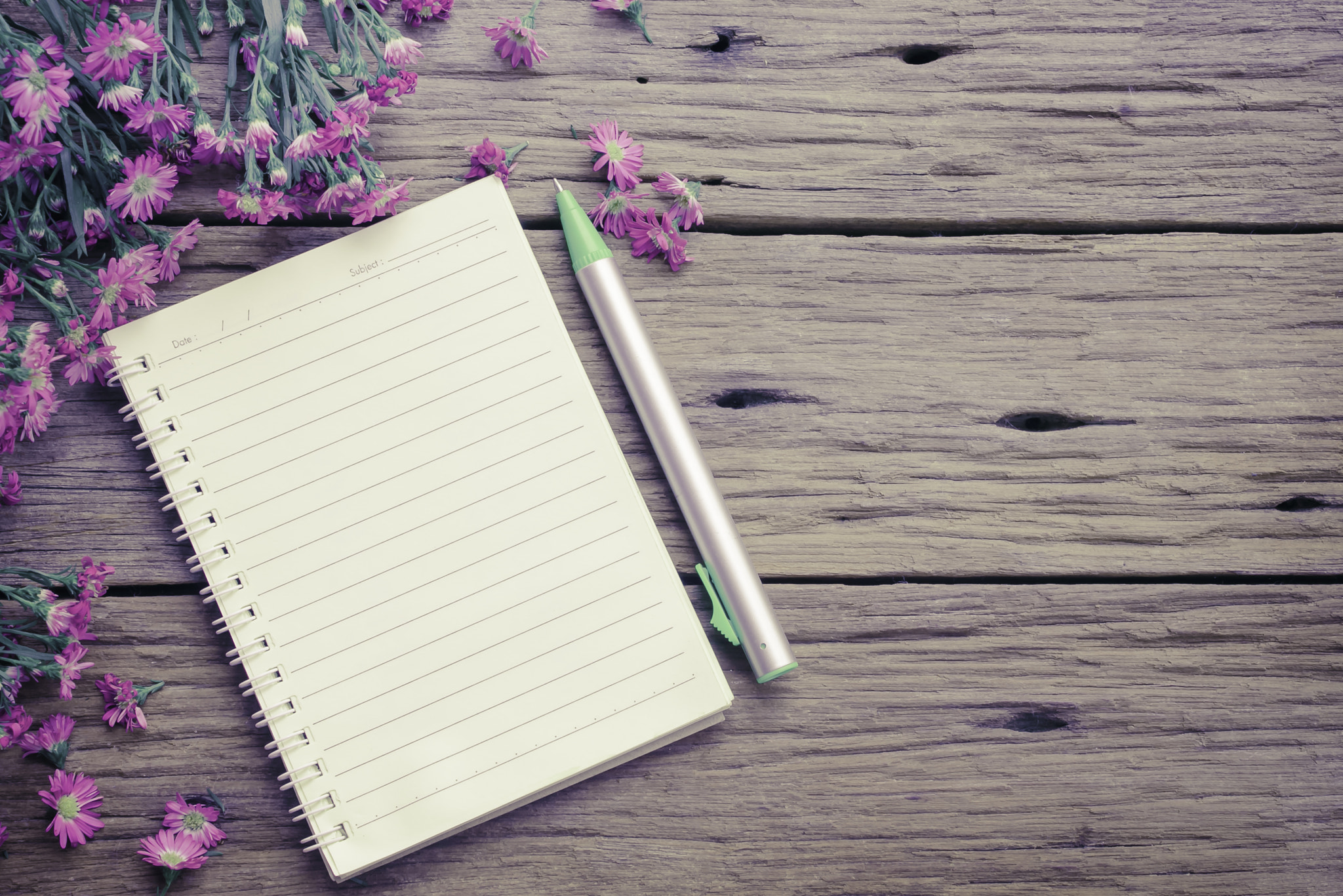 Blank notebook with flower on vintage wooden table