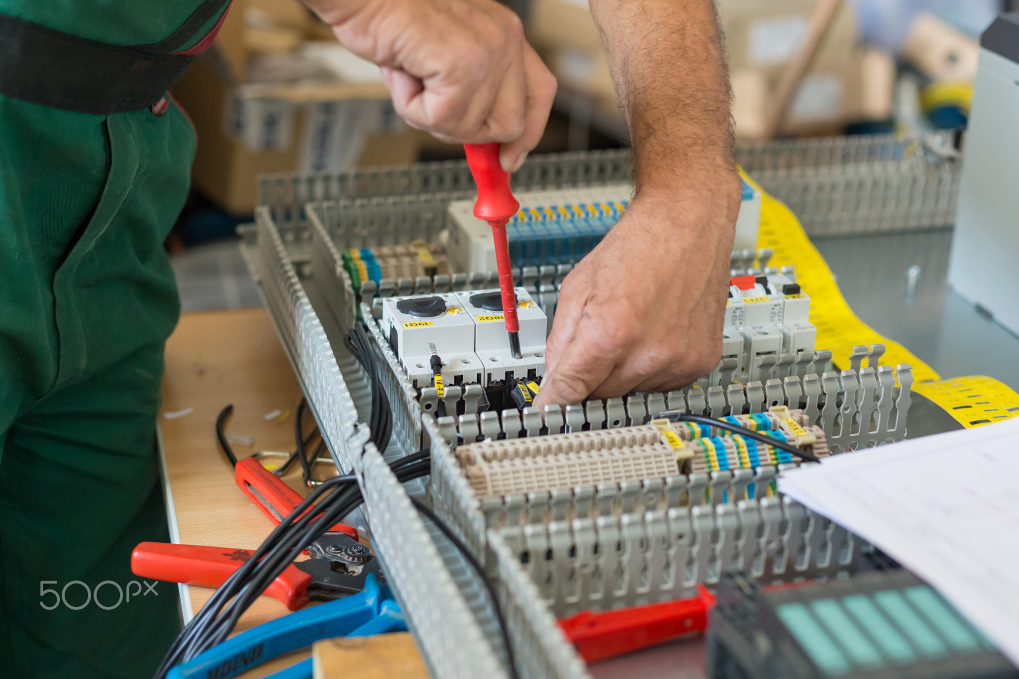 Electrician assembling industrial electric cabinet.