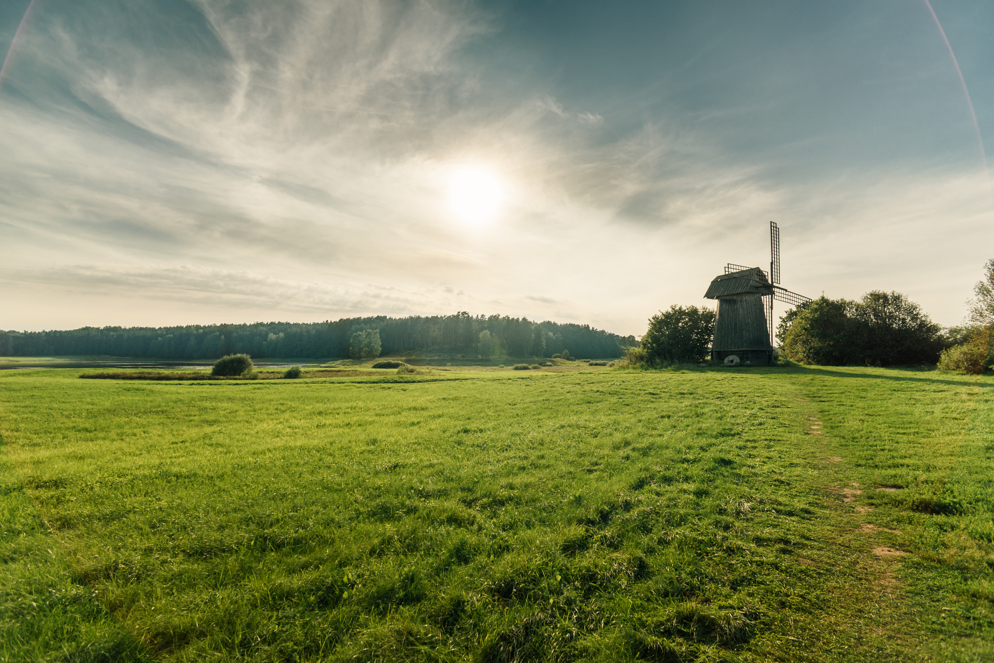 Nikon D750 + AF Nikkor 28mm f/2.8 sample photo. Windmill in green field on blue sky background with white clouds photography