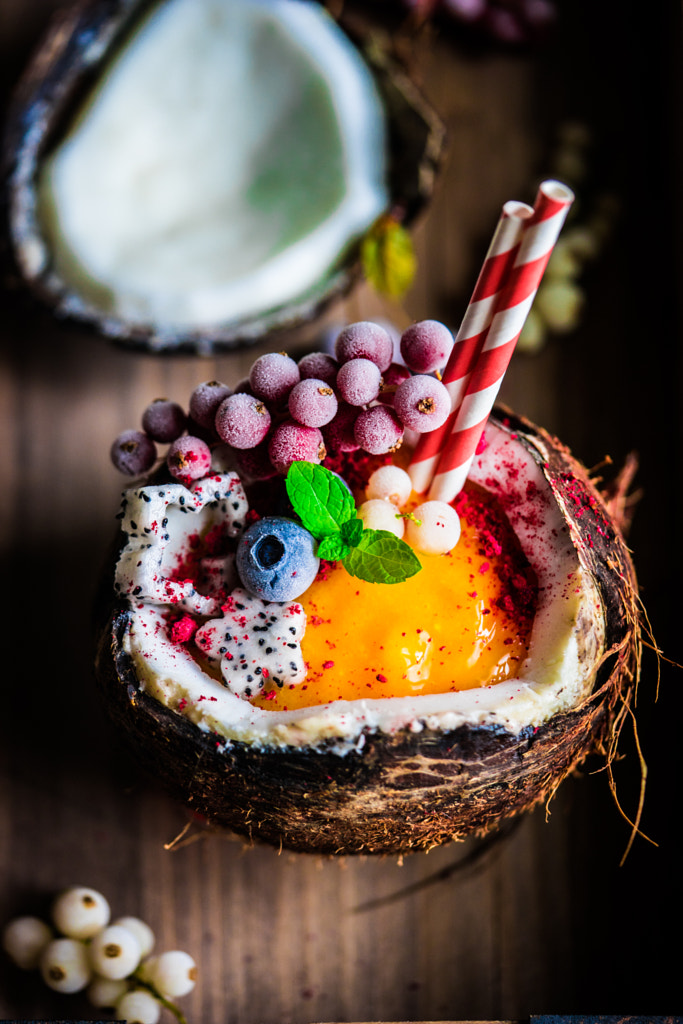 Mango smoothie in a coconut shell with berries and fruits on rus by Alena Haurylik on 500px.com