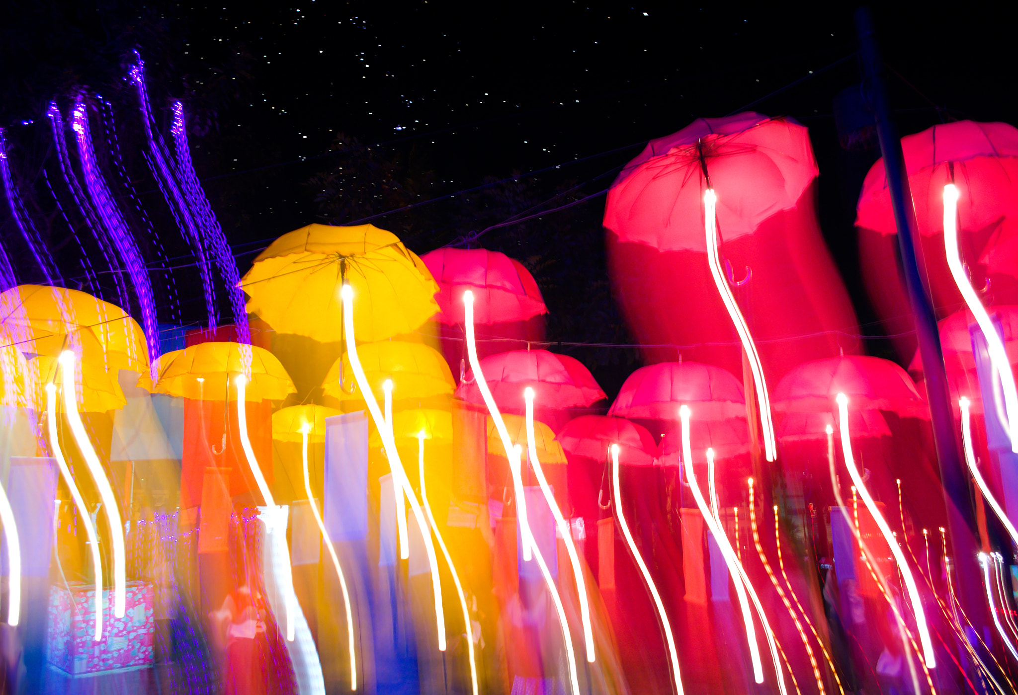 Nikon D3100 + 18.00 - 55.00 mm f/3.5 - 5.6 sample photo. Speed of umbrellas neon light photography