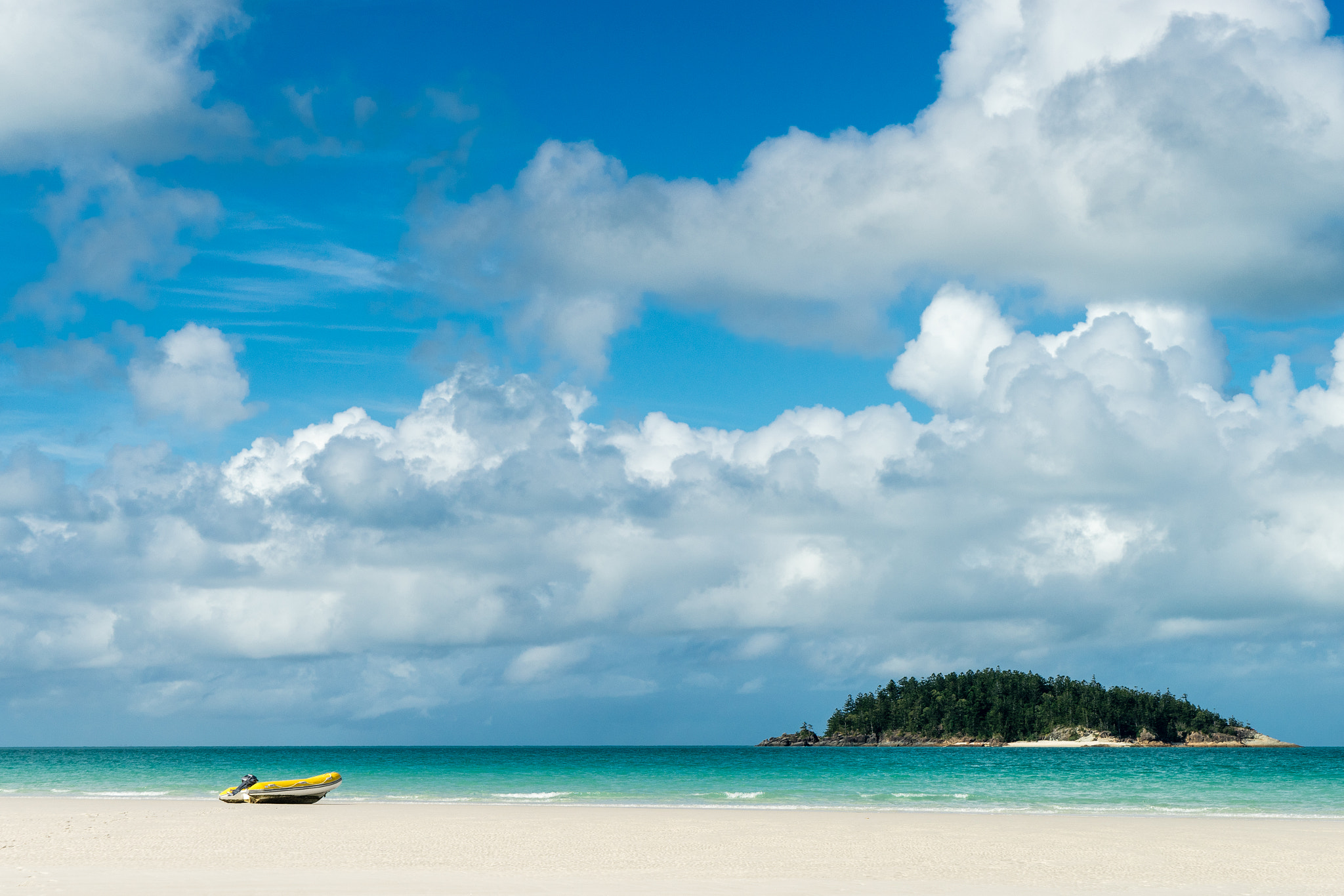 Small boat on white sand beach