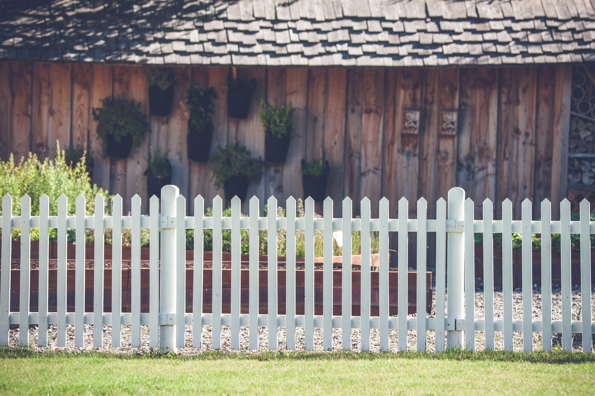 Sony 70-400mm F4-5.6 G SSM II sample photo. White picket fence in front af a wooden shed photography
