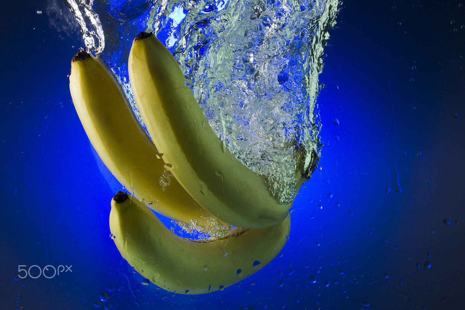 Canon EOS-1D Mark IV sample photo. Yellow bananas in water on a blue background photography