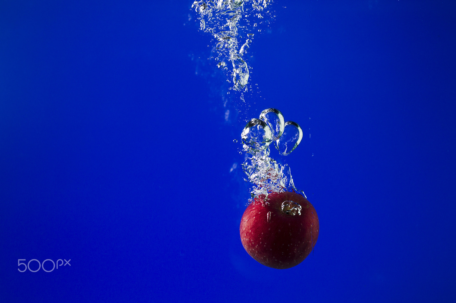 Canon EOS-1D Mark IV + Canon EF 100mm F2.8L Macro IS USM sample photo. Apple in water on a blue background photography