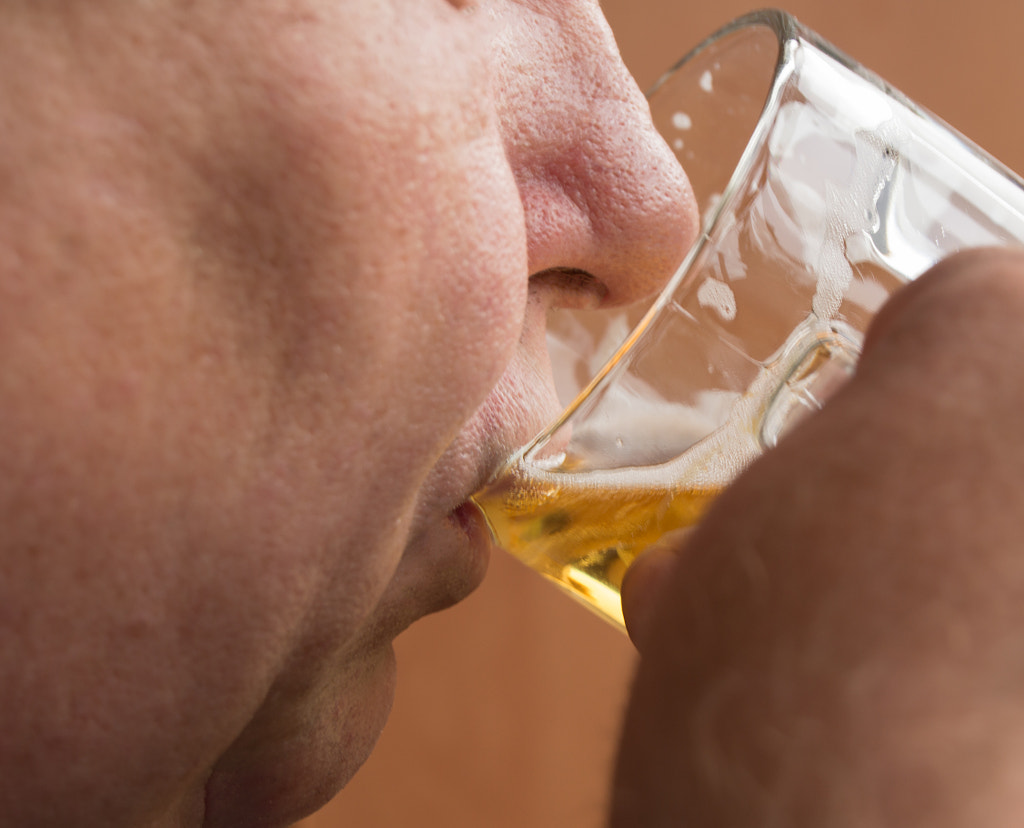 Elderly man drinks beer from glass mug, close-up by ClaireLucia on 500px.com