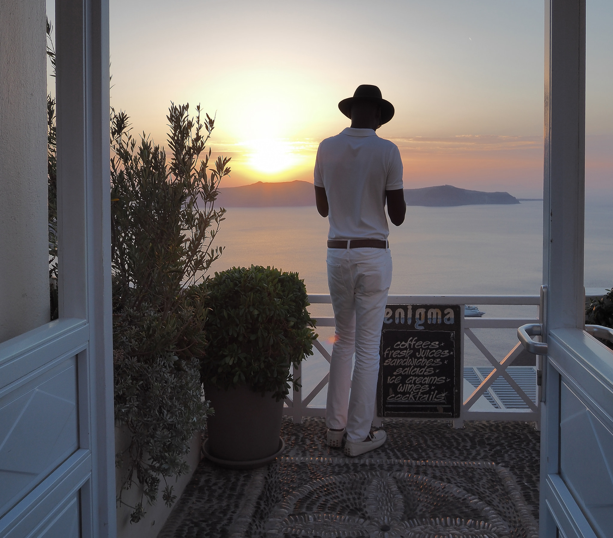 Olympus OM-D E-M5 II + LUMIX G 14/F2.5 II sample photo. Man watching sunset in fira, santorini island photography