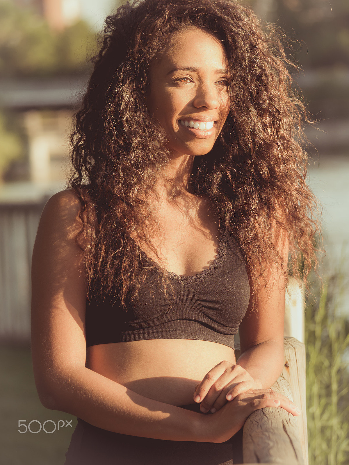 Panasonic Lumix DMC-GH3 sample photo. Young latina woman dressed in black laughing at sunset outdoors photography
