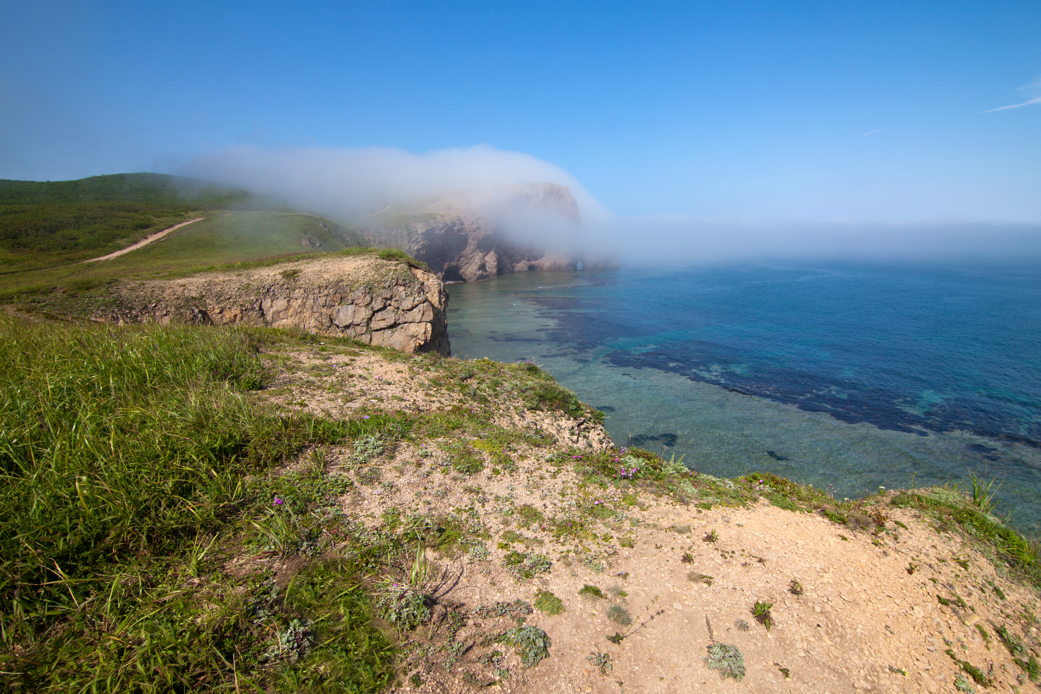 Canon EOS 5D Mark II sample photo. Fog moving to a rock from the sea photography