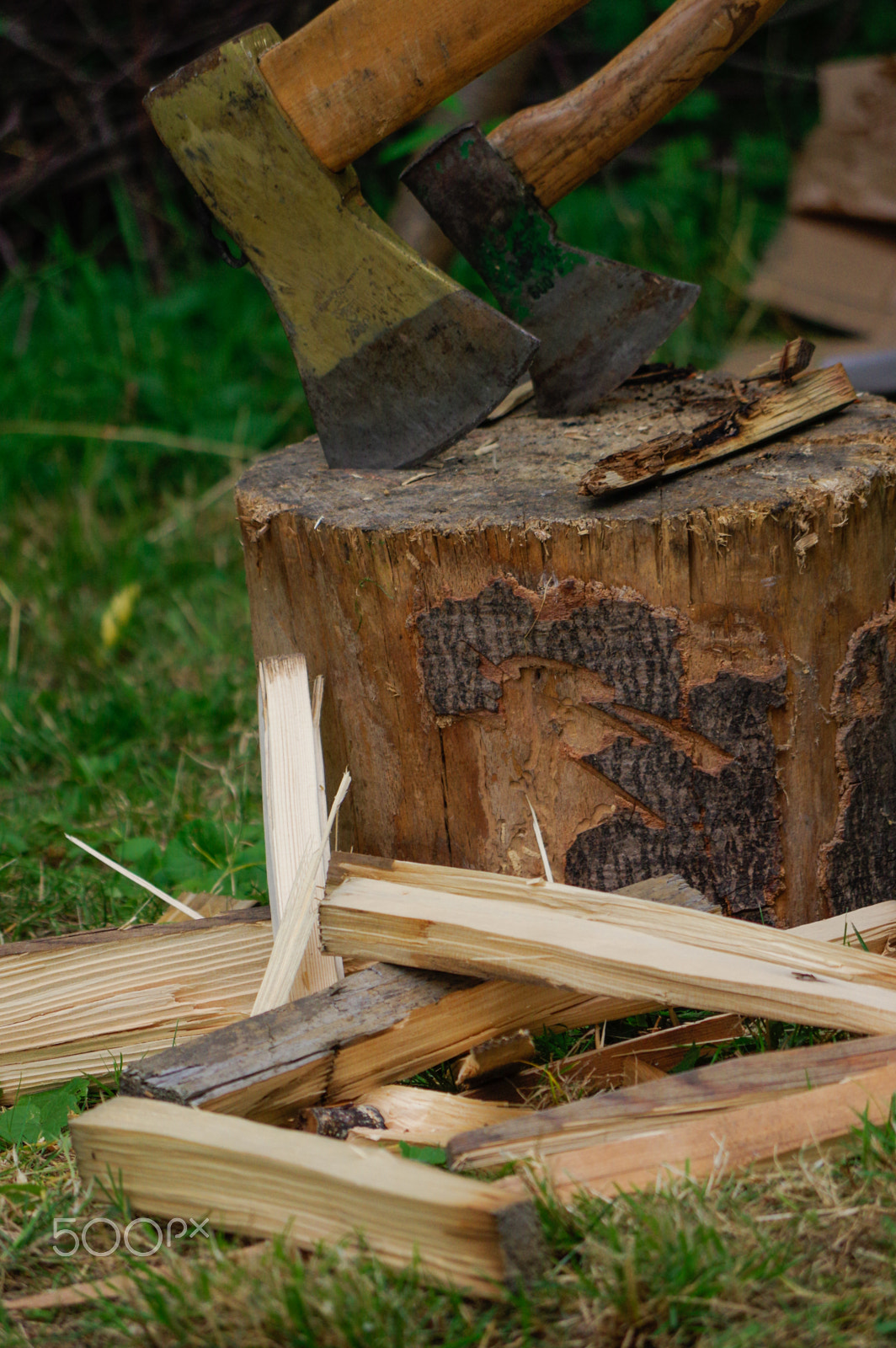 Pentax K-3 + smc Pentax-DA L 50-200mm F4-5.6 ED WR sample photo. Two ax in stump with wood crest on a background of green grass and firewood photography