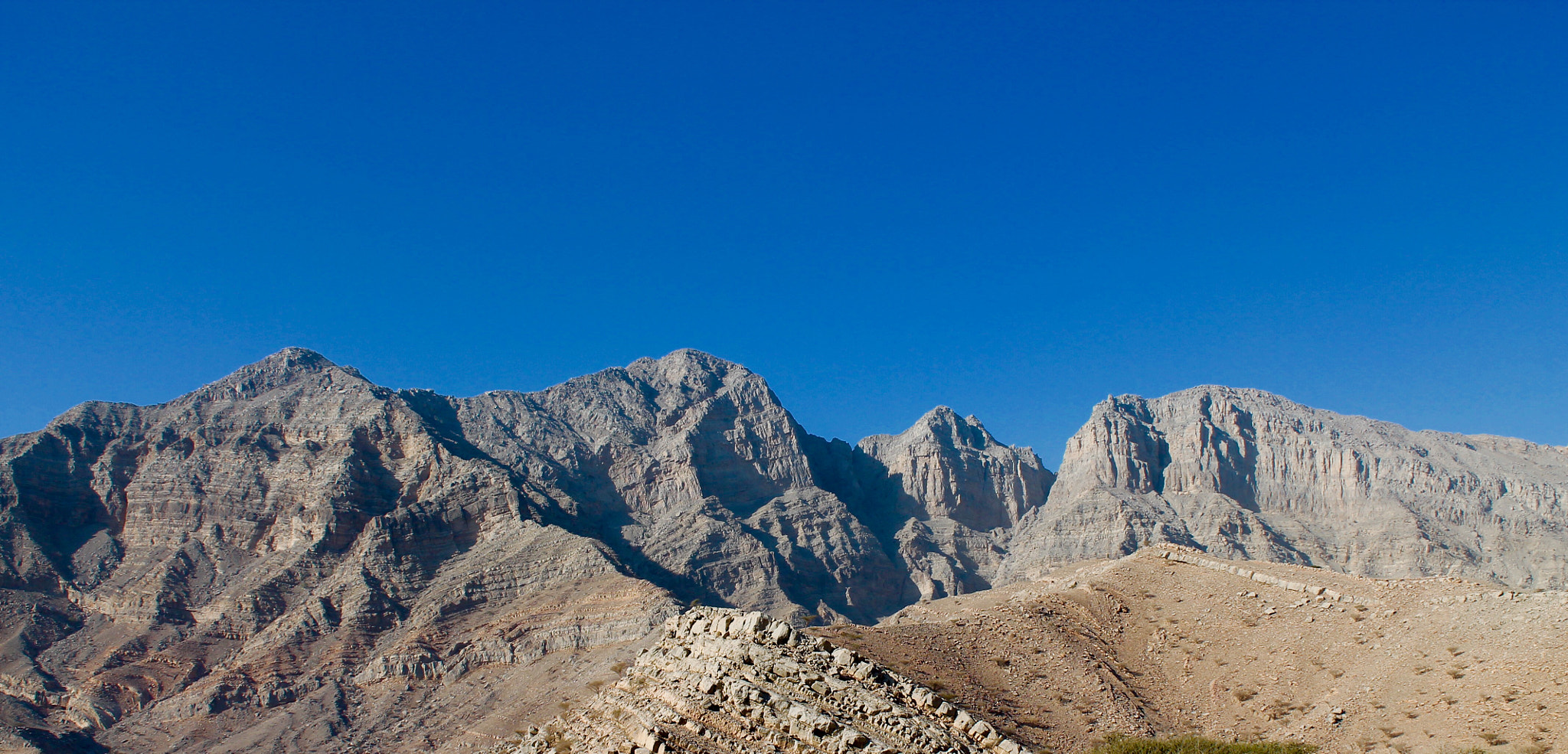 Canon EOS 1100D (EOS Rebel T3 / EOS Kiss X50) sample photo. Rugged foothills of the hajjar mountains bathed in clear blue sky's photography