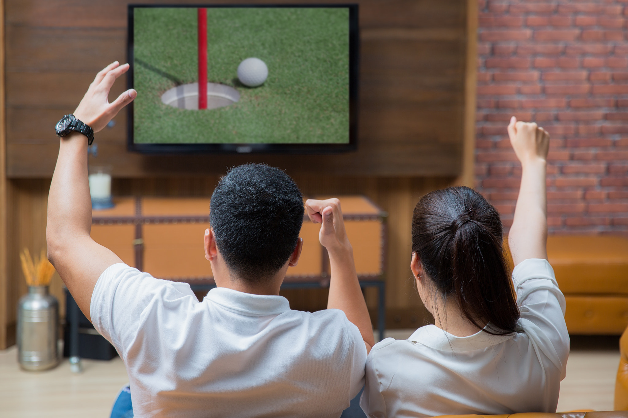 Asian Couple having fun watching golf game