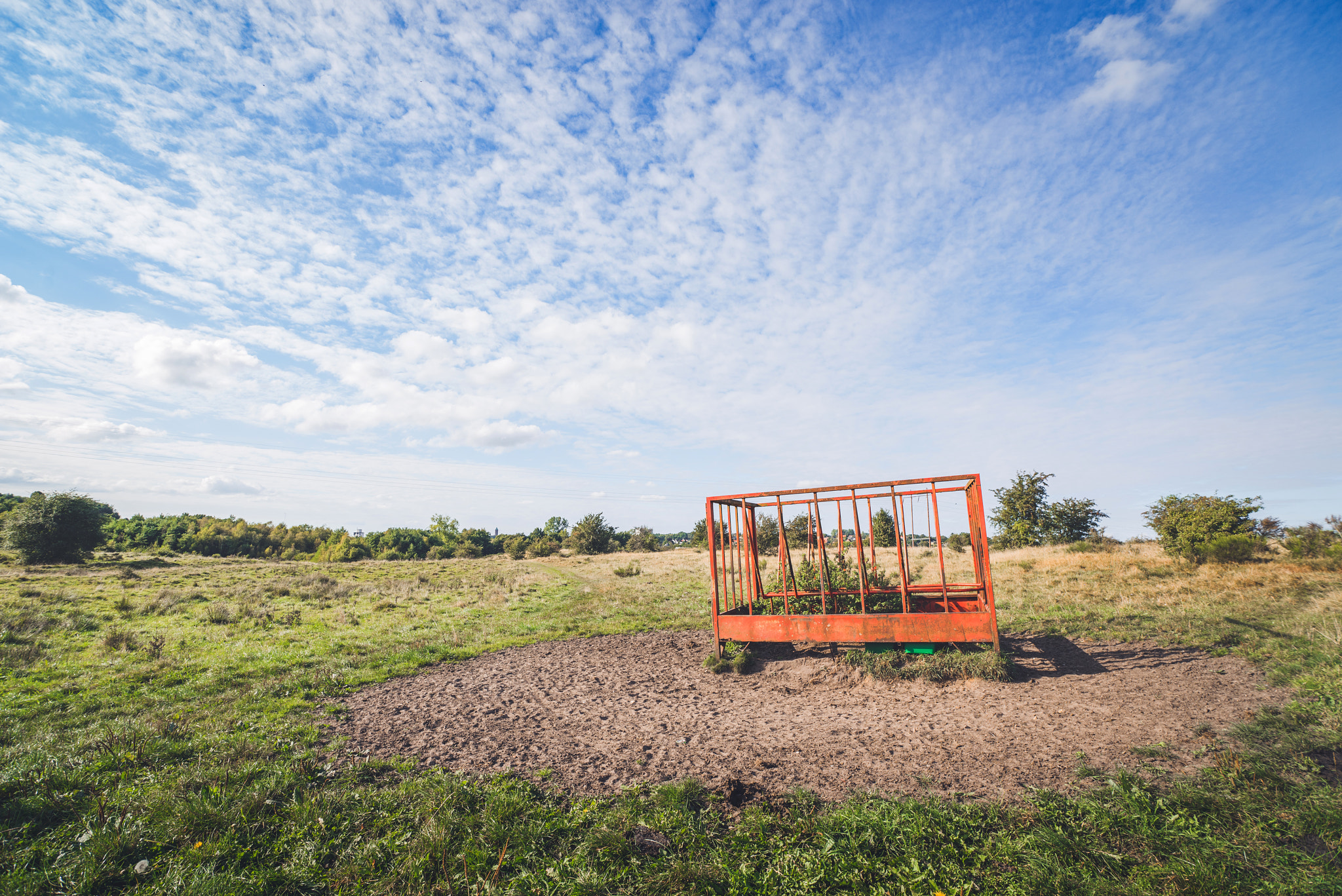 Sony a7R + Sony Vario-Sonnar T* 16-35mm F2.8 ZA SSM sample photo. Rural field with a red cage photography