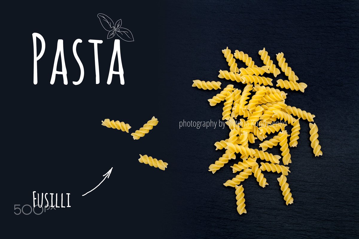 Canon EOS 1000D (EOS Digital Rebel XS / EOS Kiss F) sample photo. Uncooked italian pasta fusilli on black slate stone background photography