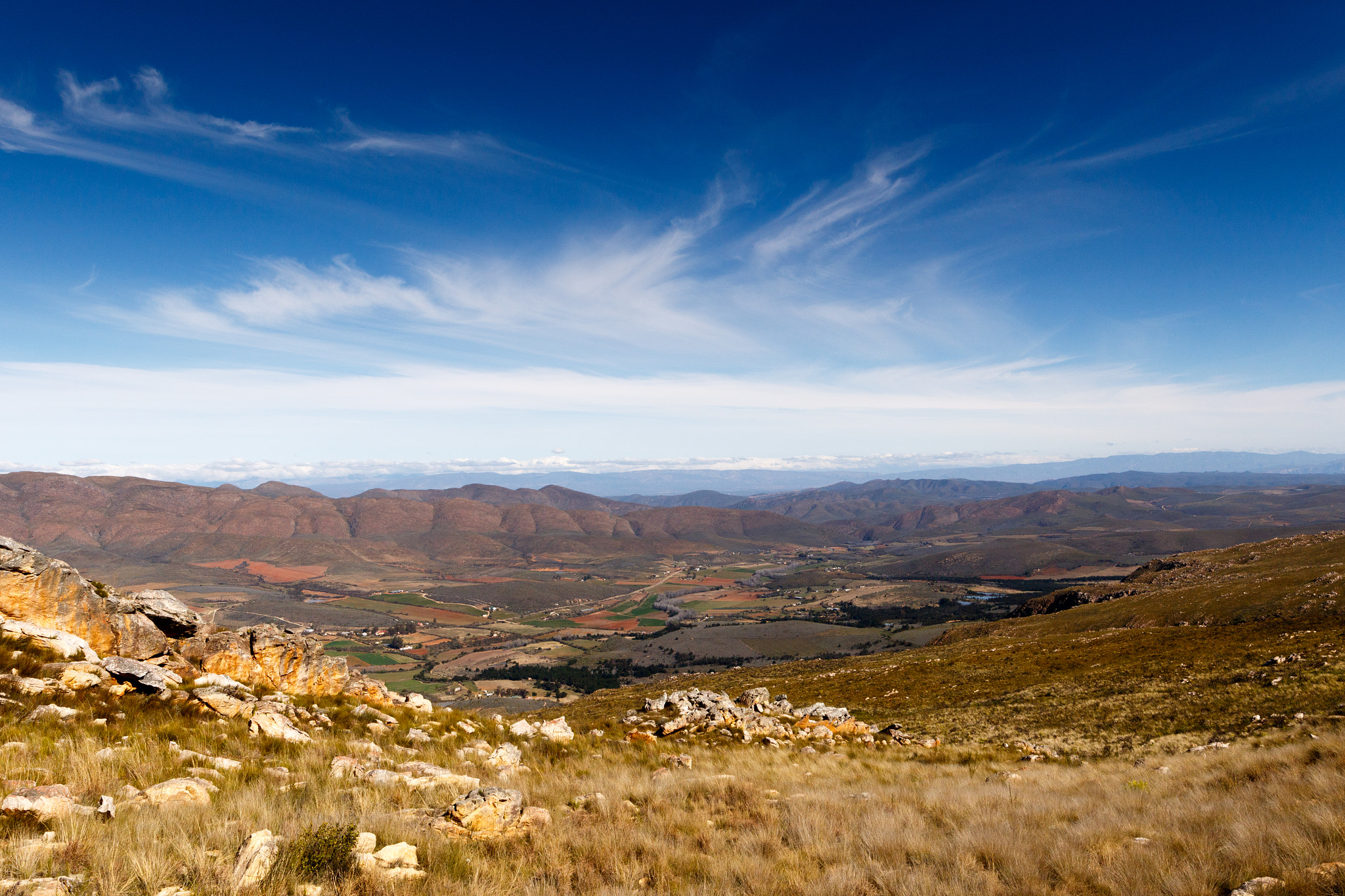 Canon EF 300mm f/2.8L sample photo. Green valley surrounded by mountains with storm clouds photography