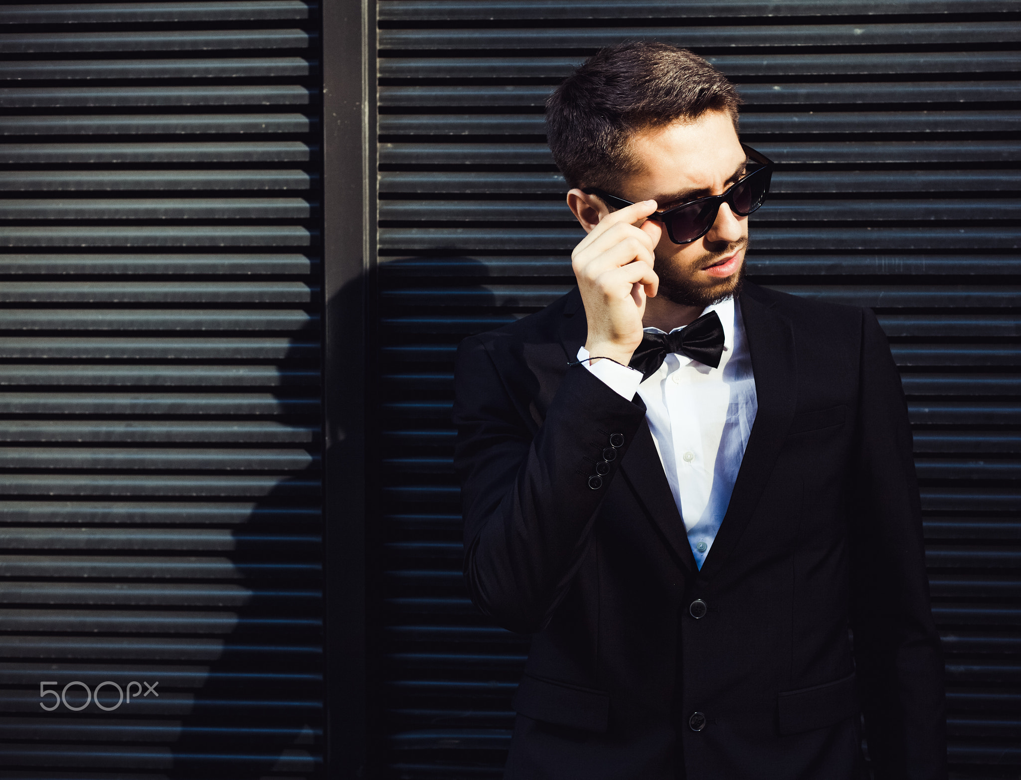 Portrait of a businessman in a suit and sunglasses. Hipster.