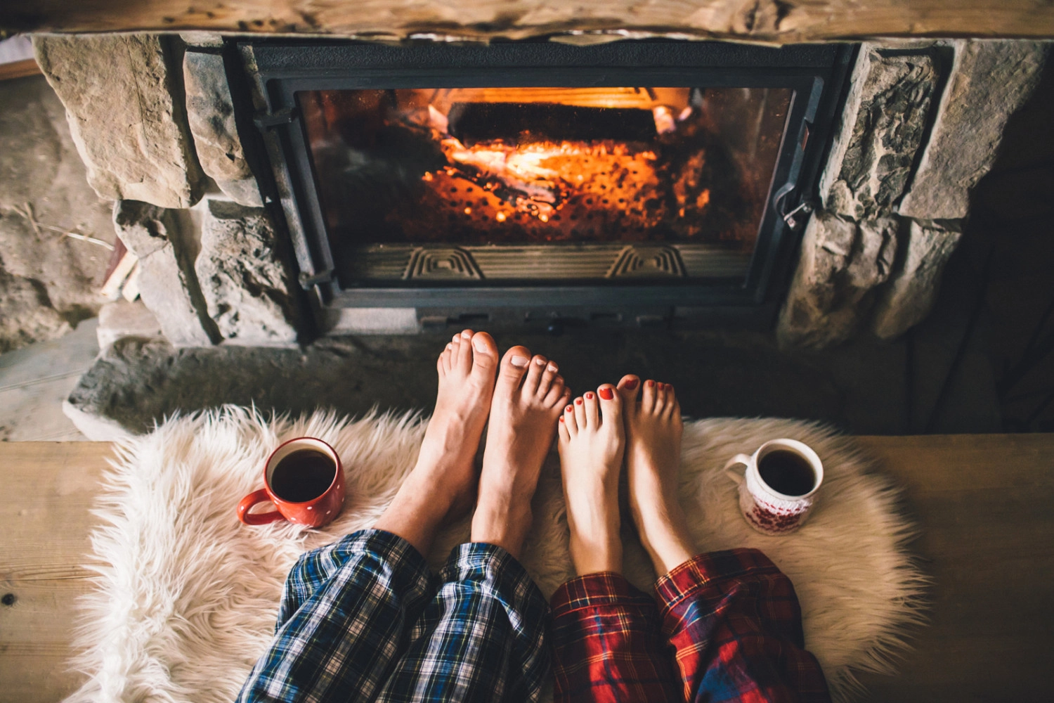 Sony a7S II + Canon EF 35mm F1.4L USM sample photo. Bare couple feet by the cozy fireplace. man and woman relaxes by warm fire with a cup of hot... photography