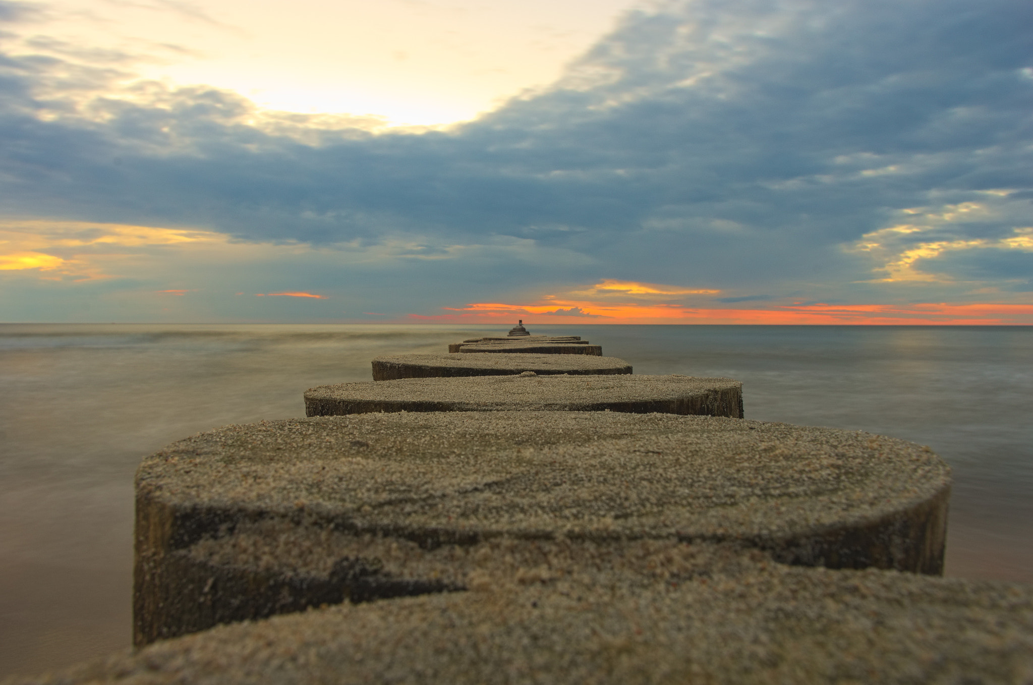 Pentax K-5 sample photo. Wooden poles at baltic sea photography