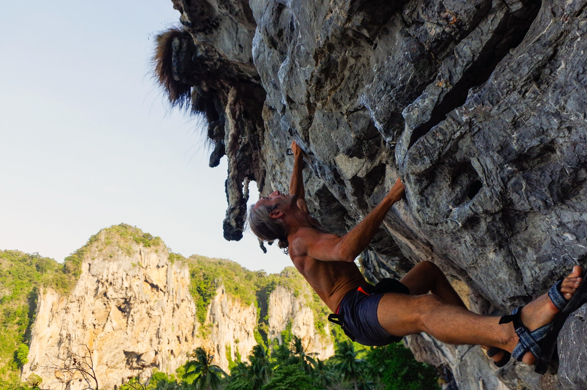 Pentax K-3 sample photo. Strong and happy man climbing on high rock over the sea with a h photography