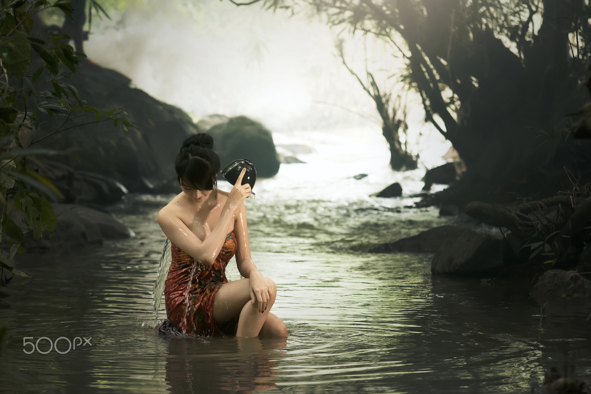 Rural women is bathing at waterfall .