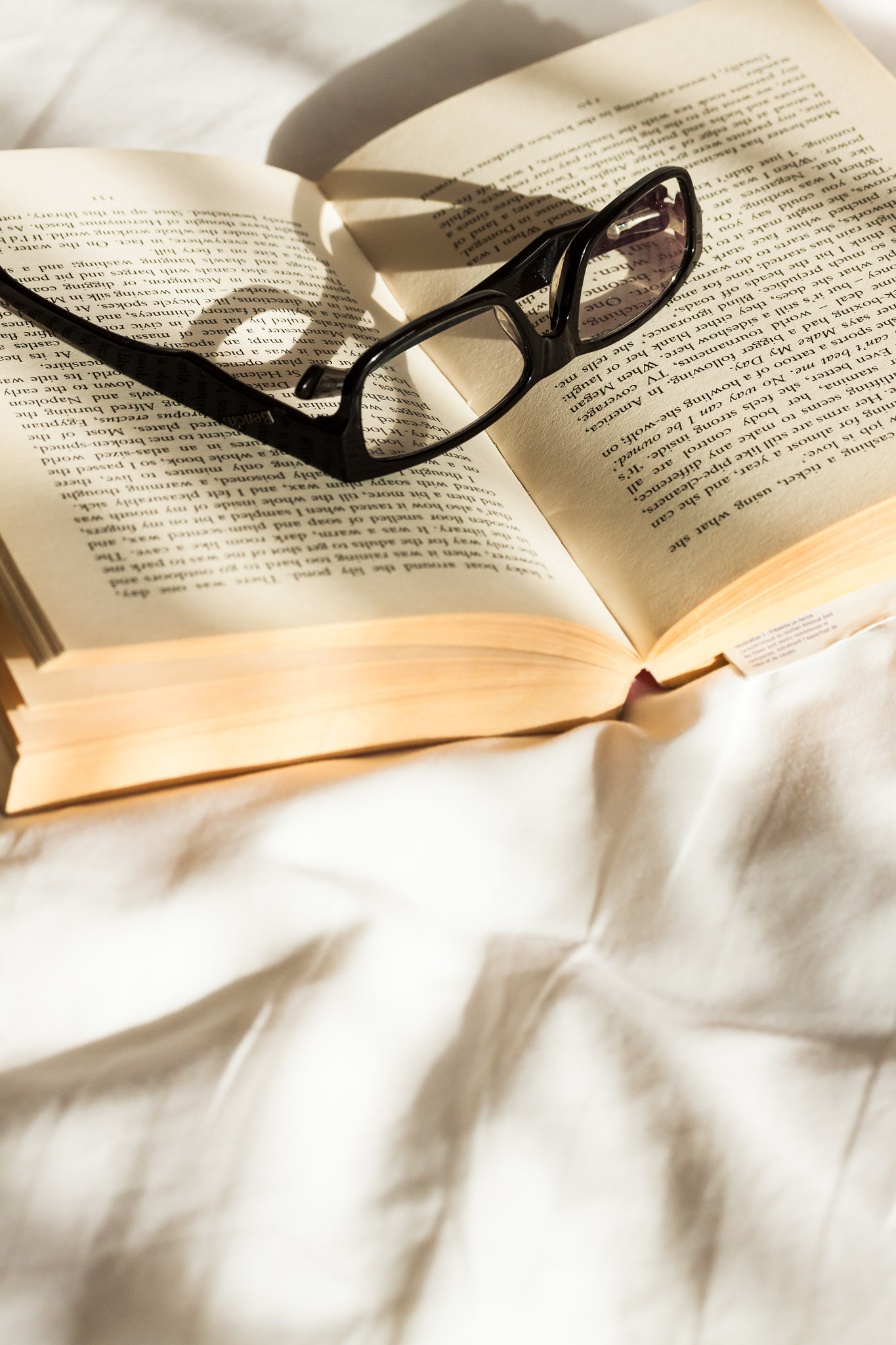 Canon EOS 50D sample photo. Glasses resting on a book on an unmade bed lit by morning sunshine photography