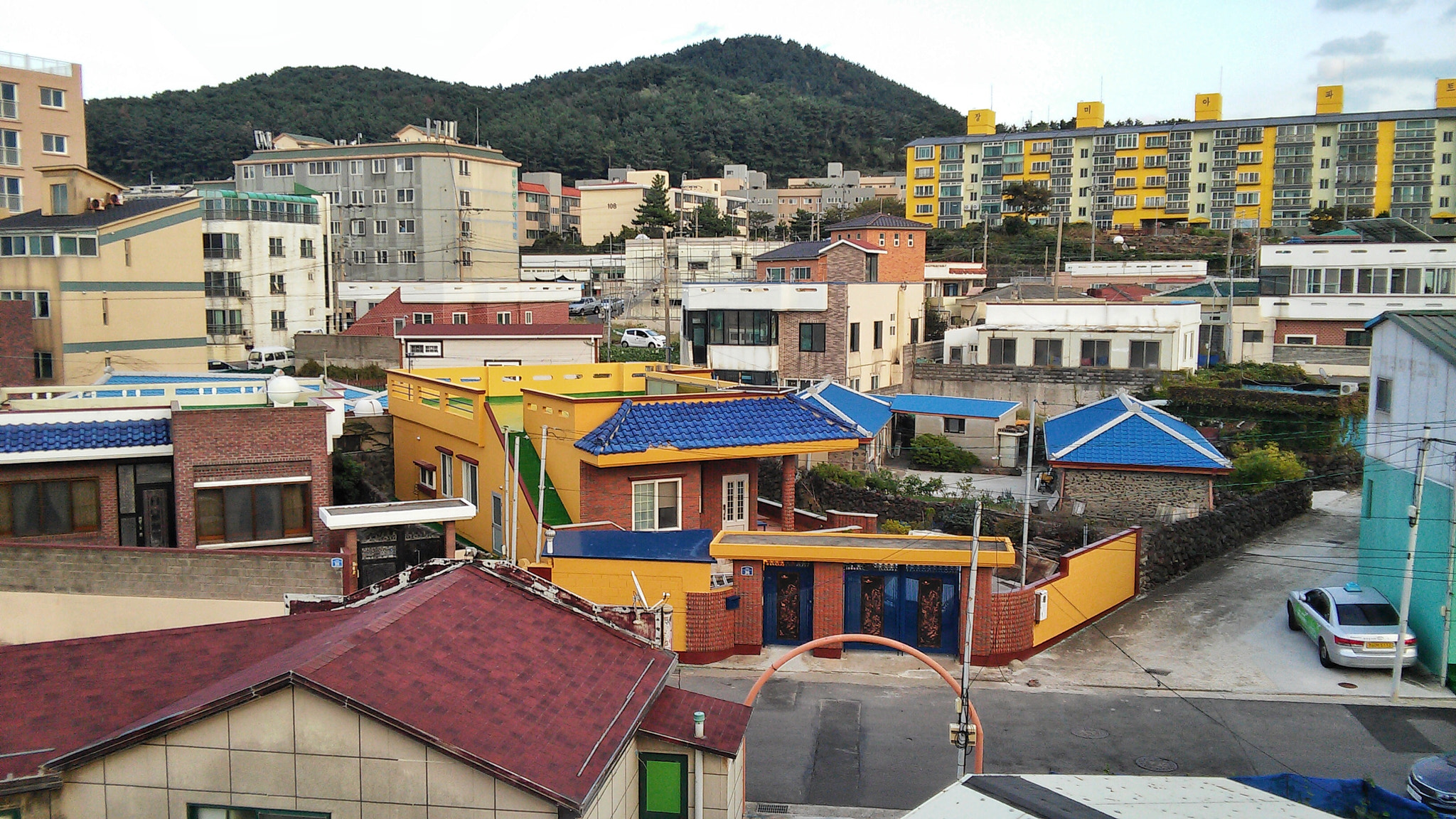 LG G3 Beat sample photo. Colorful rooftops and buildings along the samyang black sand beach, jeju island photography