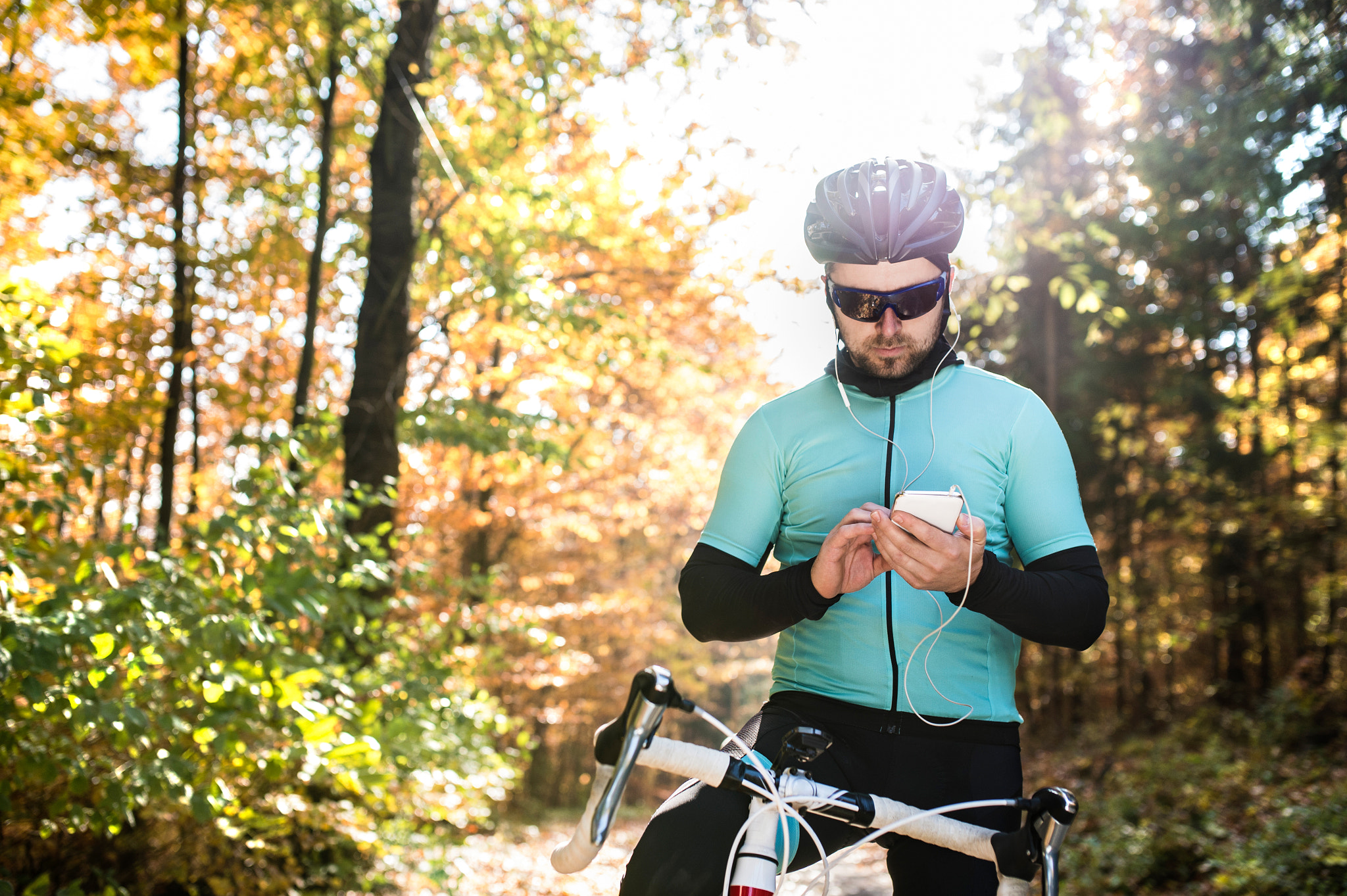 Nikon D4S sample photo. Young sportsman riding bicycle, holding smartphone, sunny autumn photography