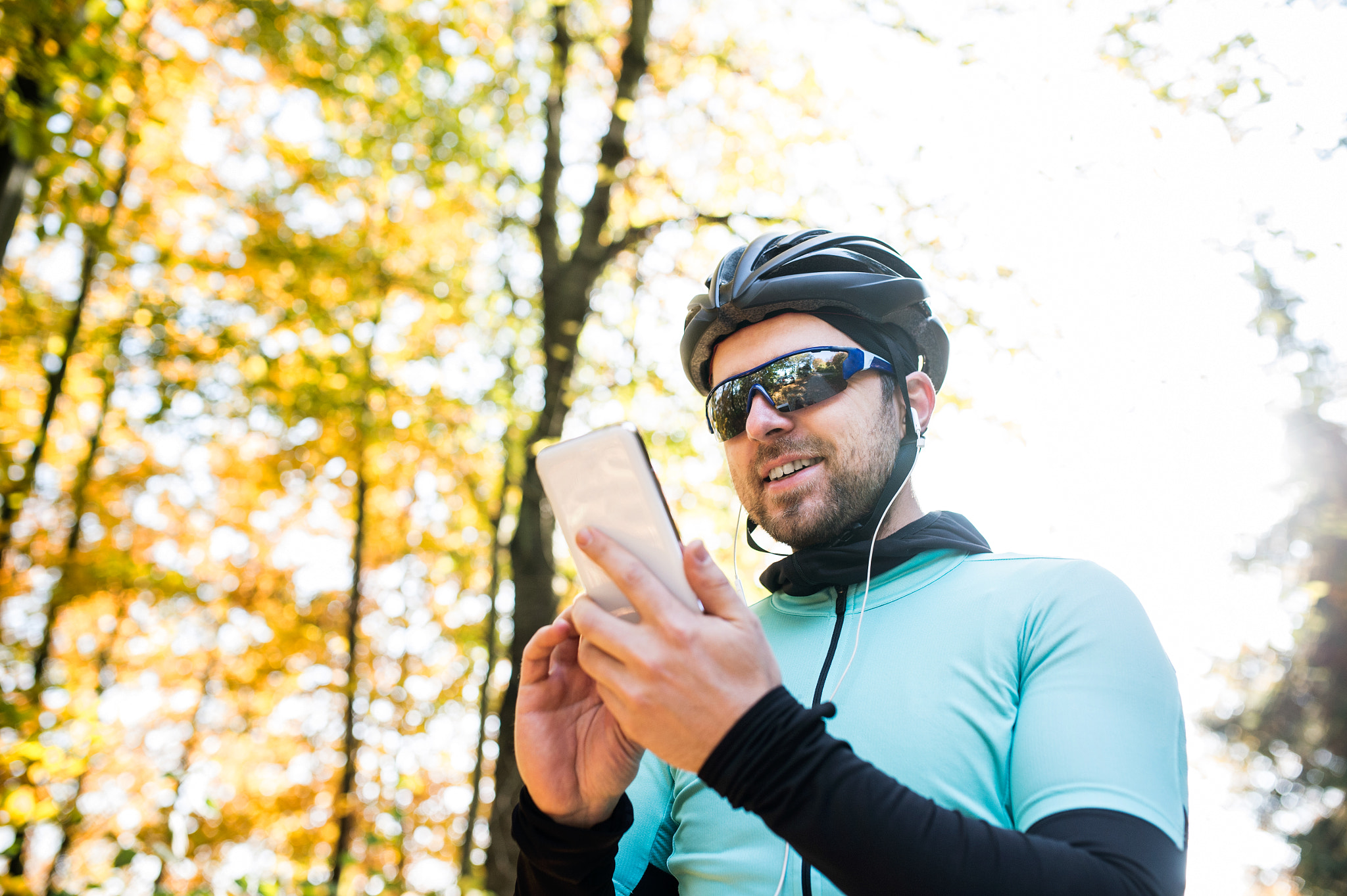 Nikon D4S sample photo. Young sportsman riding bicycle, holding smartphone, sunny autumn photography