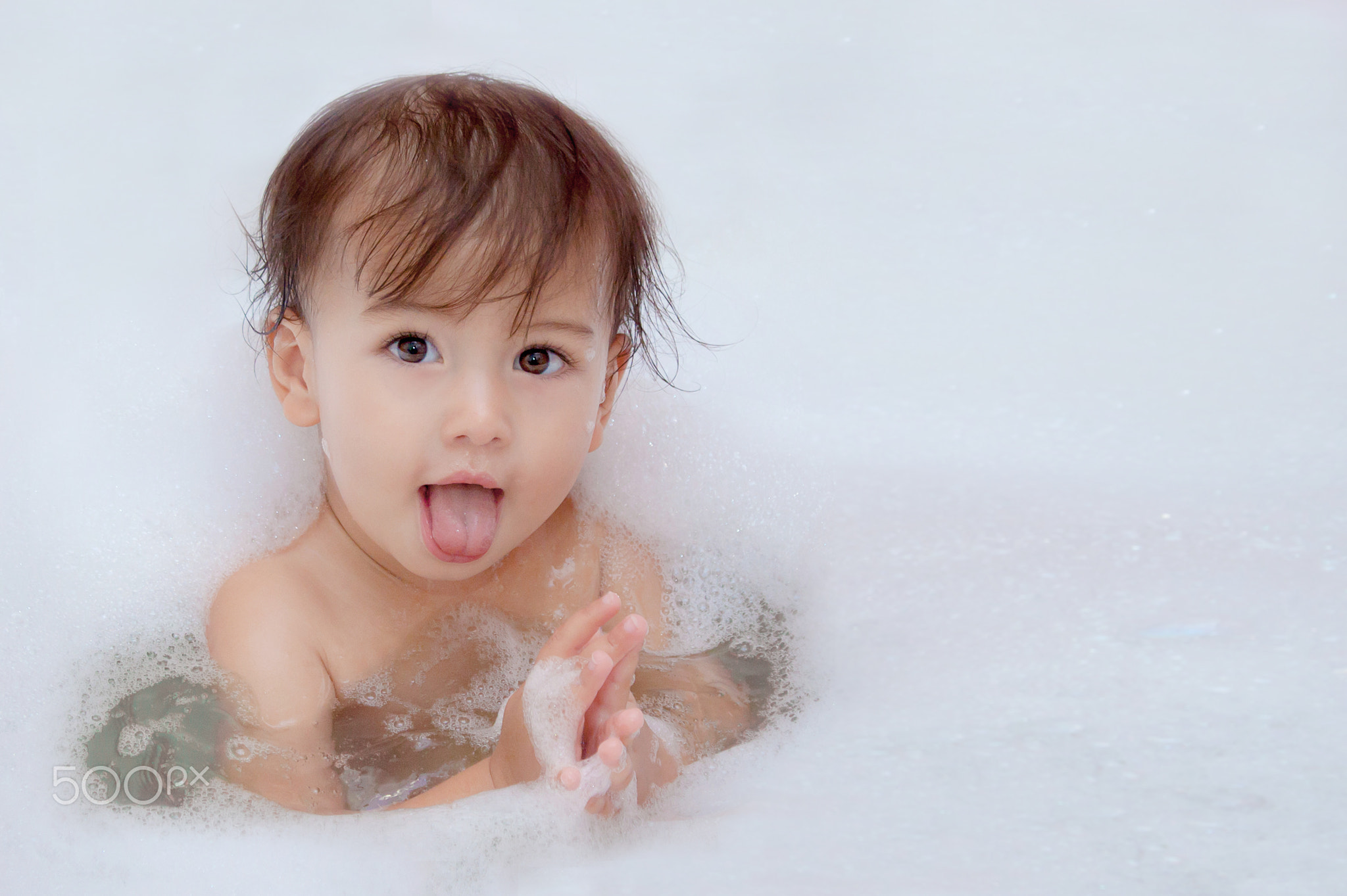 cute baby is swimming in bath